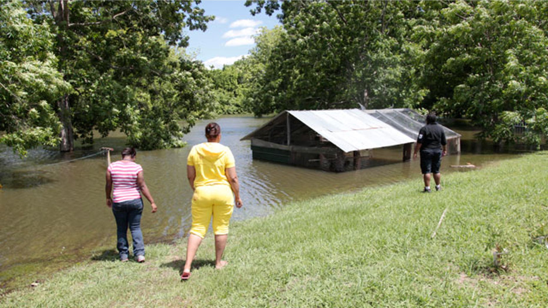 Sherrel Hall, right, and Debra Prater, left, look at rising floodwaters from the Atchafalaya River as it encroaches on a shed where camps and homes sit in Simmesport, La., Monday, May 16, 2011.
