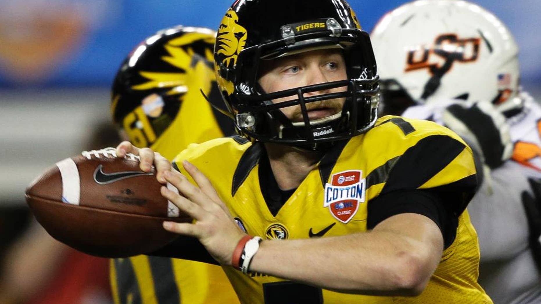 FILE - In this Jan. 3, 2014 file photo, Missouri quarterback Maty Mauk (7) rolls back to pass against Oklahoma State during the second half of the Cotton Bowl NCAA college football game in Arlington, Texas. Mauk feels more confident on and off the field in the first few days of his second playing season with the Tigers. (AP Photo/Tim Sharp, File)