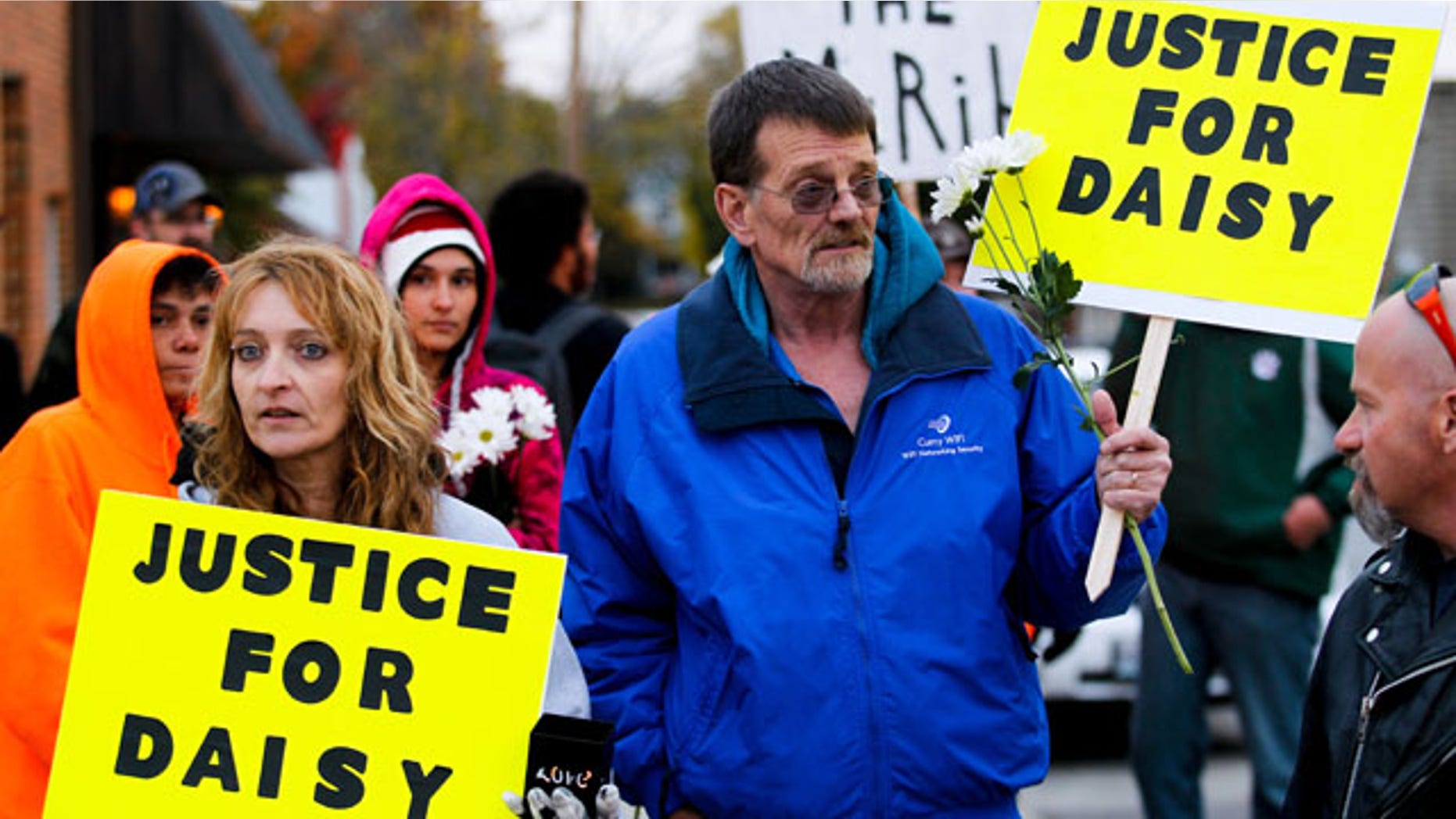 October 22, 2013: Shana Curry, left, and her husband Scott Curry hold signs at the "Justice for Daisy" rally in Maryville, Mo. The rally was organized on the Internet on behalf of Daisy Coleman, a girl who says she was sexually assaulted nearly two years ago when she was 14. (AP Photo/The St. Joseph News-Press, Sait Serkan Gurbuz)