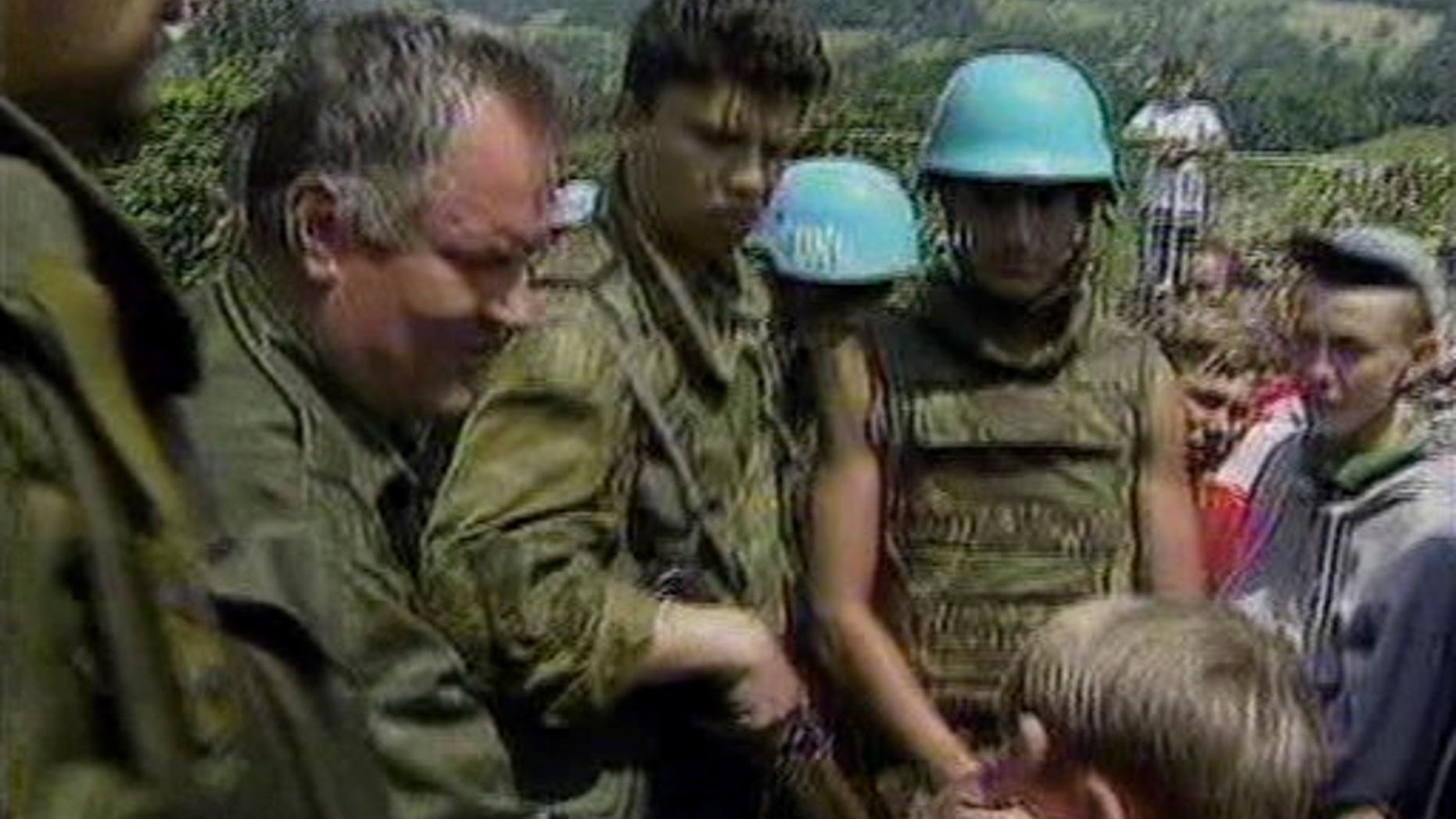 July 12, 1995: Bosnian Serb General Ratko Mladic pats a young Muslim boy on the head as he assures residents of Srebrenica they would be safe, after his arrival in Srebrenica, Bosnia. Gen. Ratko Mladic, the brutal Bosnian Serb general suspected of leading the bloody massacre of 8,000 Muslim men and boys, was arrested in an early morning raid Thursday May 26, 2011 in Serbia after more than a decade hiding from genocide charges, the country's president said.