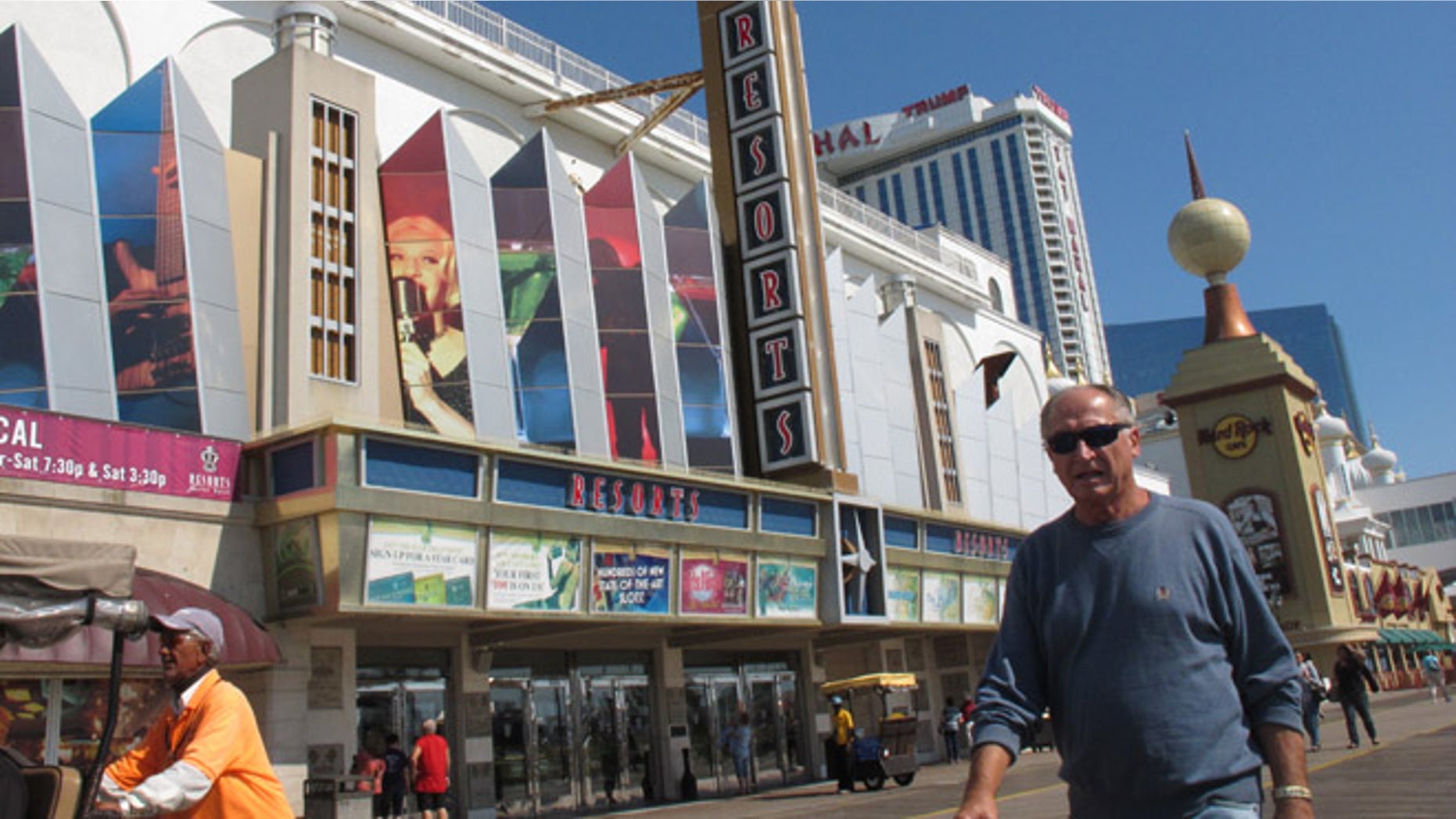 Pedestrians walk in front of Resorts Casino Hotel on Friday, Sept. 14, 2012, in Atlantic City, N.J. New Jersey casino regulators announced Friday they would allow the Mohegan Indian tribe of Connecticut to run the day-to-day affairs of Resorts. The Mohegan Indian tribe plans to oversee a $35 million expansion of Resorts that will include a Jimmy Buffett-themed Margaritaville complex. (AP Photo/Wayne Parry)
