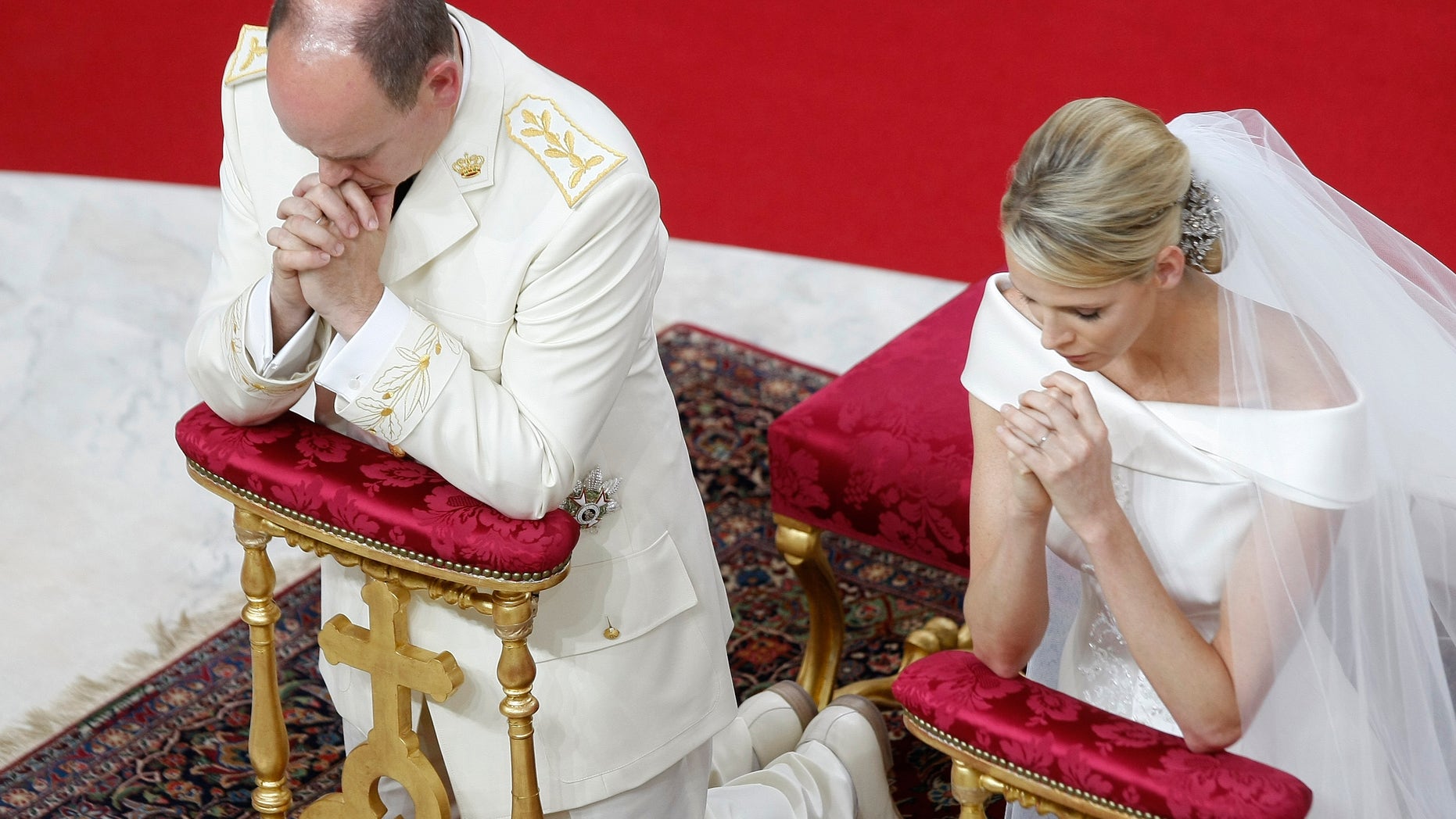 Prince Albert II of Monaco and Charlene Princess of Monaco kneel in prayer during their religious wedding ceremony at the Monaco palace, Saturday, July 2, 2011.