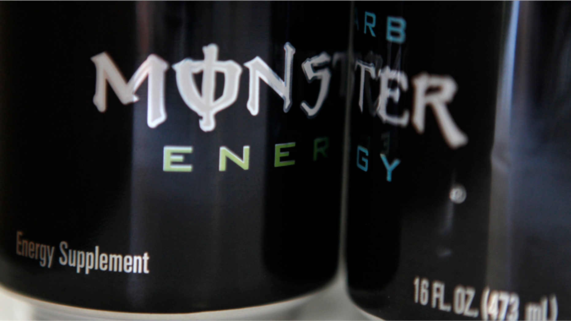 Two cans of Monster energy drink.