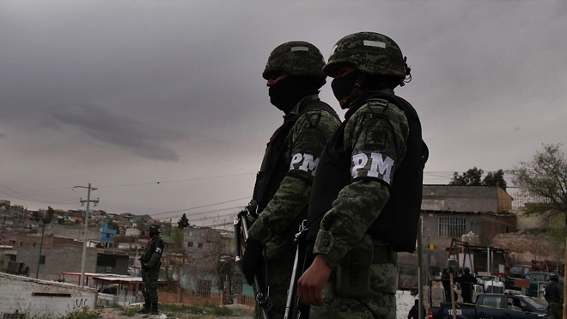 JUAREZ, MEXICO - MARCH 23: Military police stand guard at the scene of a murder on March 23, 2010 in Juarez, Mexico. Secretary of State Hillary Rodham Clinton, Defense Secretary Robert Gates, and Homeland Security Secretary Janet Napolitano all visited Mexico on today for discussions centered on Mexico's endemic drug-related violence. The border city of Juarez, Mexico has been racked by violent drug-related crime recently and has quickly become one of the most dangerous cities in the world in which to live. As drug cartels have been fighting over ever-lucrative drug corridors along the United States border, the murder rate in Juarez has risen to 173 slayings for every 100,000 residents. President Felipe Calderon's strategy of sending 7000 troops to Juarez has not mitigated the situation. With a population of 1.3 million, 2,600 people died in drug-related violence last year and 500 so far this year, including two Americans recently who worked for the U.S. Consulate and were killed as they returned from a child's party. (Photo by Spencer Platt/Getty Images)