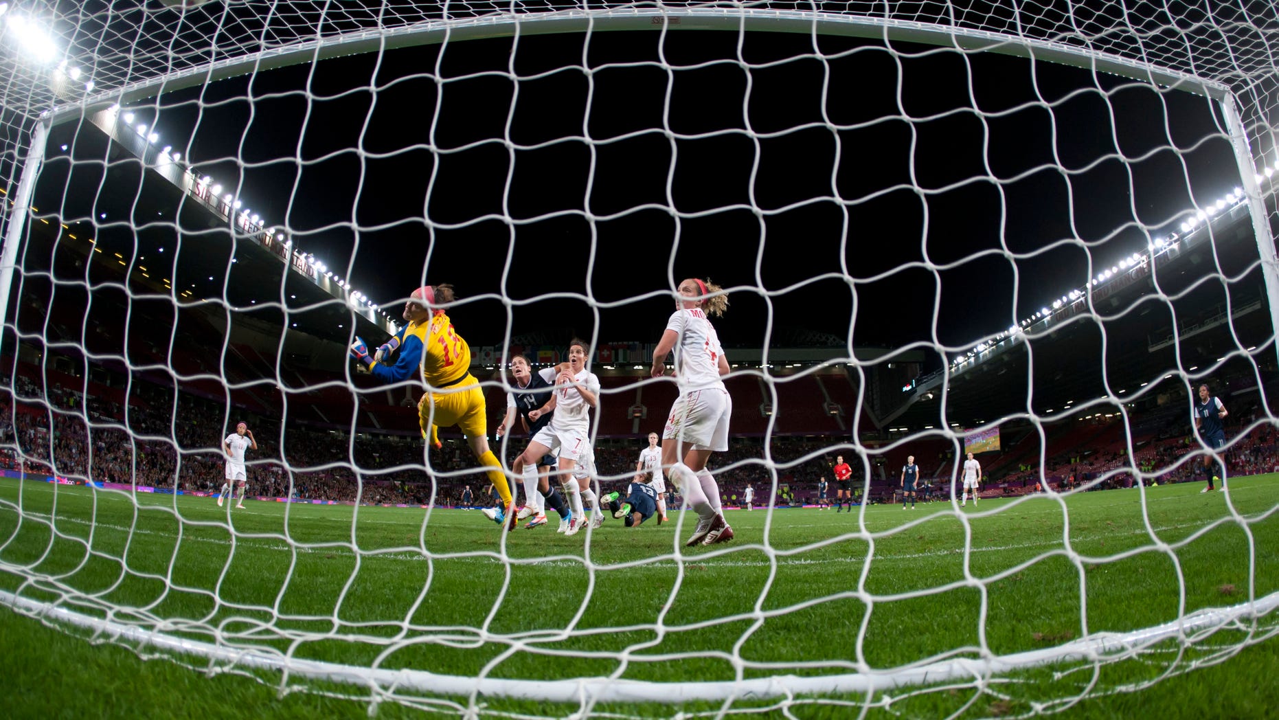 Aug. 6, 2012: Canada's goalkeeper Erin Mcleod, center left, dives in vain as the United States' Alex Morgan, bottom center, scores the winning goal during their semifinal women's soccer match at the 2012 London Summer Olympics at Old Trafford Stadium in Manchester, England.