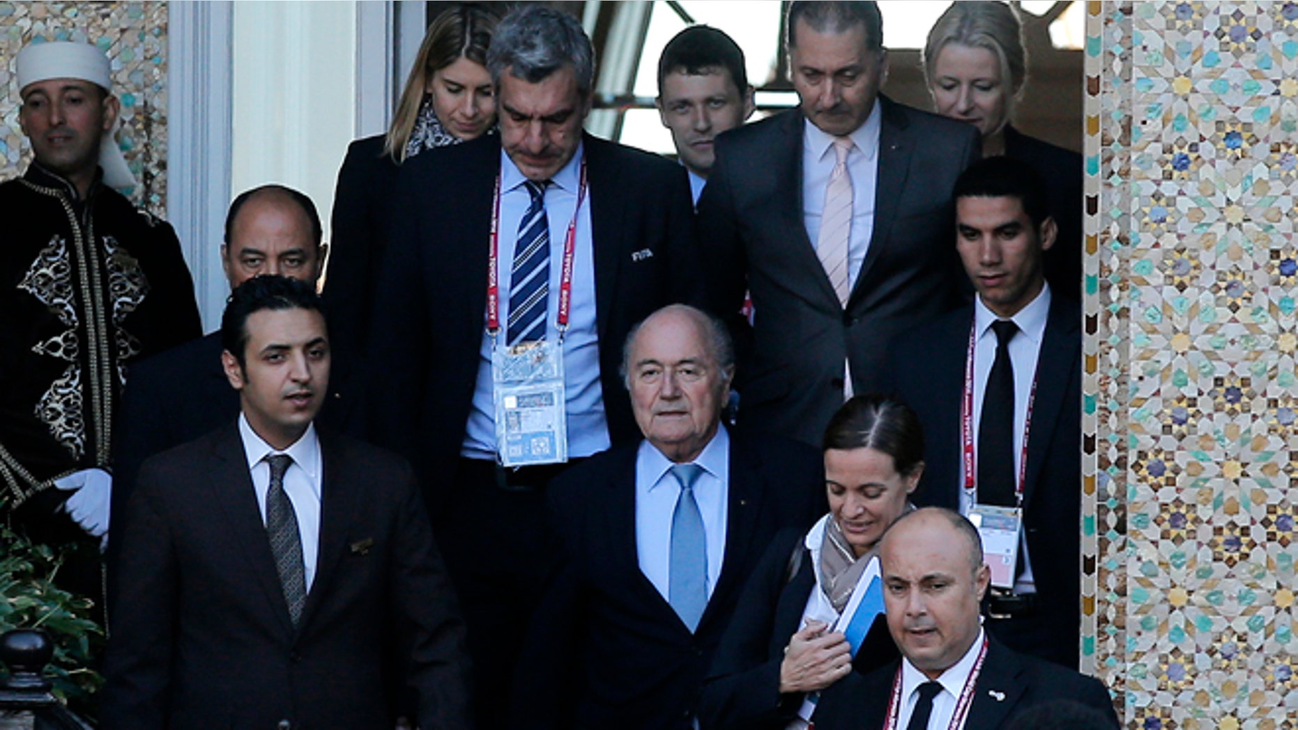 FIFA president Sepp Blatter, center, leaves a hotel to lead a meeting in Marrakech, Morocco, Thursday, Dec. 18, 2014. Amid another crisis at FIFA, Blatter will lead an executive committee meeting on Thursday with the sudden resignation of ethics prosecutor Michael Garcia now on the agenda. (AP Photo/Christophe Ena)