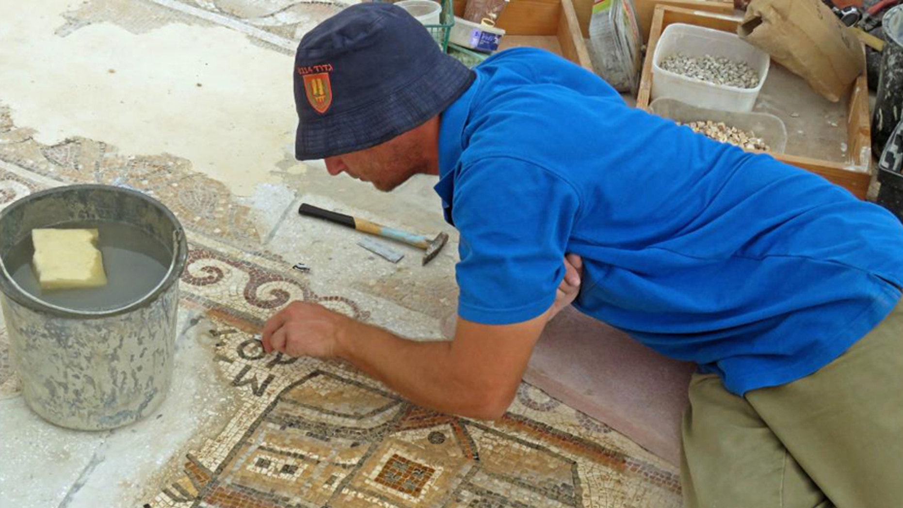 A worker of the Israel Antiquities Authority conserving the mosaic.
