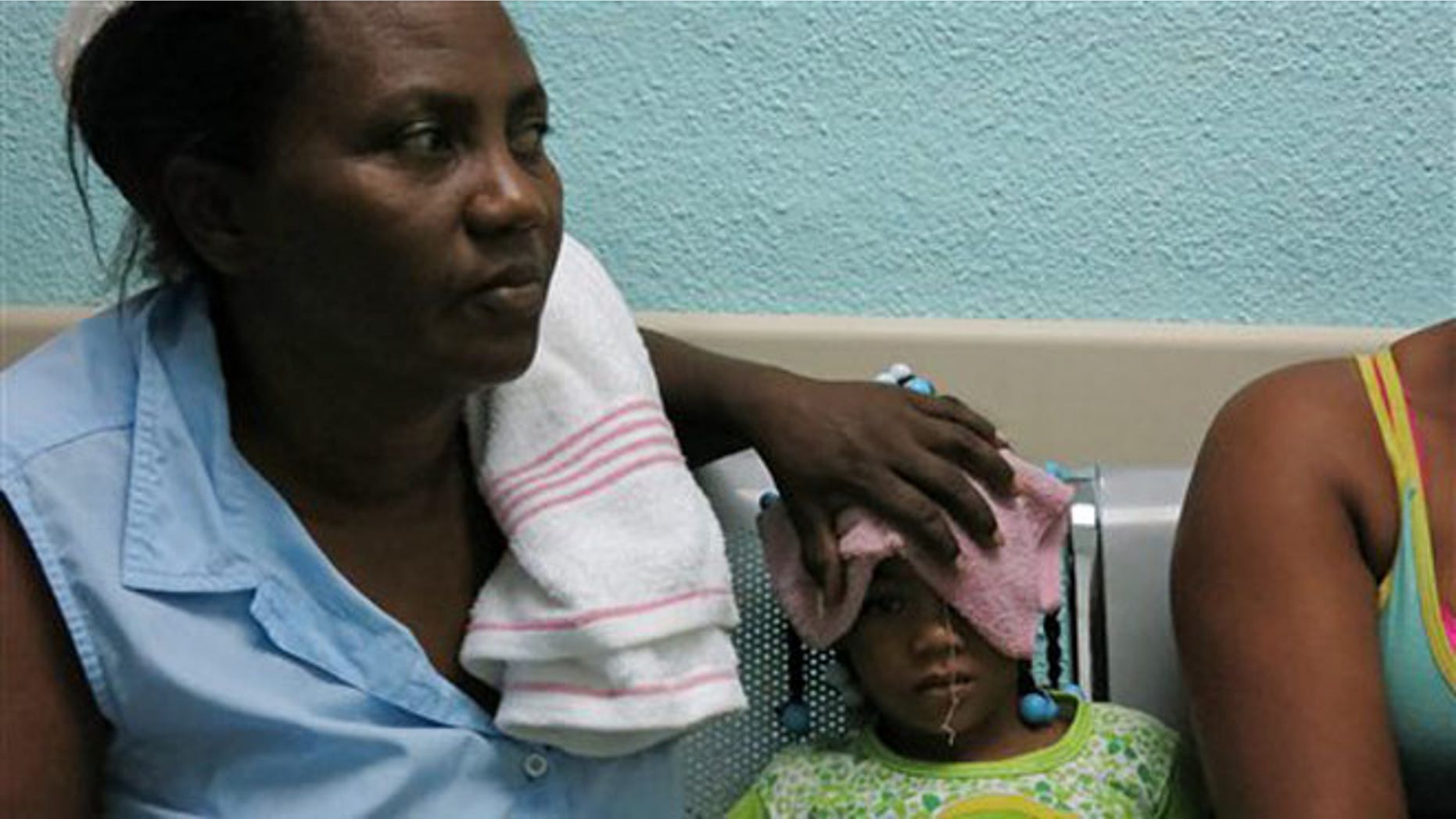 In this May 15, 2014 photo, five-year-old Karla Sepulveda, who suffers chikungunya fever symptoms, waits with her grandmother for treatment in the pediatric area of a public hospital in the coastal town of Boca Chica, Dominican Republic. The mosquito-born virus, common in Africa and Asia, arrived to the Caribbean in late 2013 and has affected more than 10,000 people in the Dominican Republic. (AP Photo/Ezequiel Abiu Lopez)