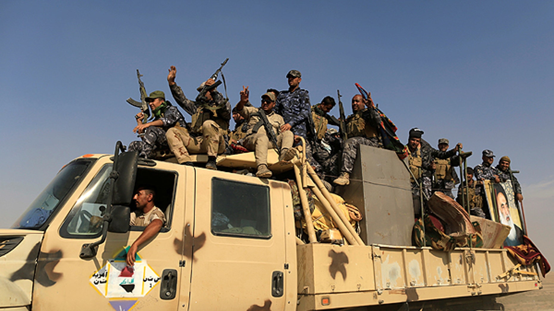 Newly trained police formed from people displaced by Islamic State militants sit on a truck bound for the frontline of the Mosul offensive against Islamic State, near Bazgirtan, Iraq, October 26, 2016. REUTERS/Zohra Bensemra - RTX2QIET