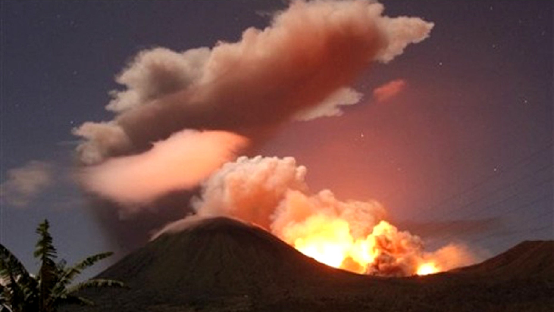 July 14, 2011: The glow of lava from Mount Lokon's eruption is seen against the night sky in July, 2011. The volcano erupted yet again early Tuesday, Dec. 27, 2011.