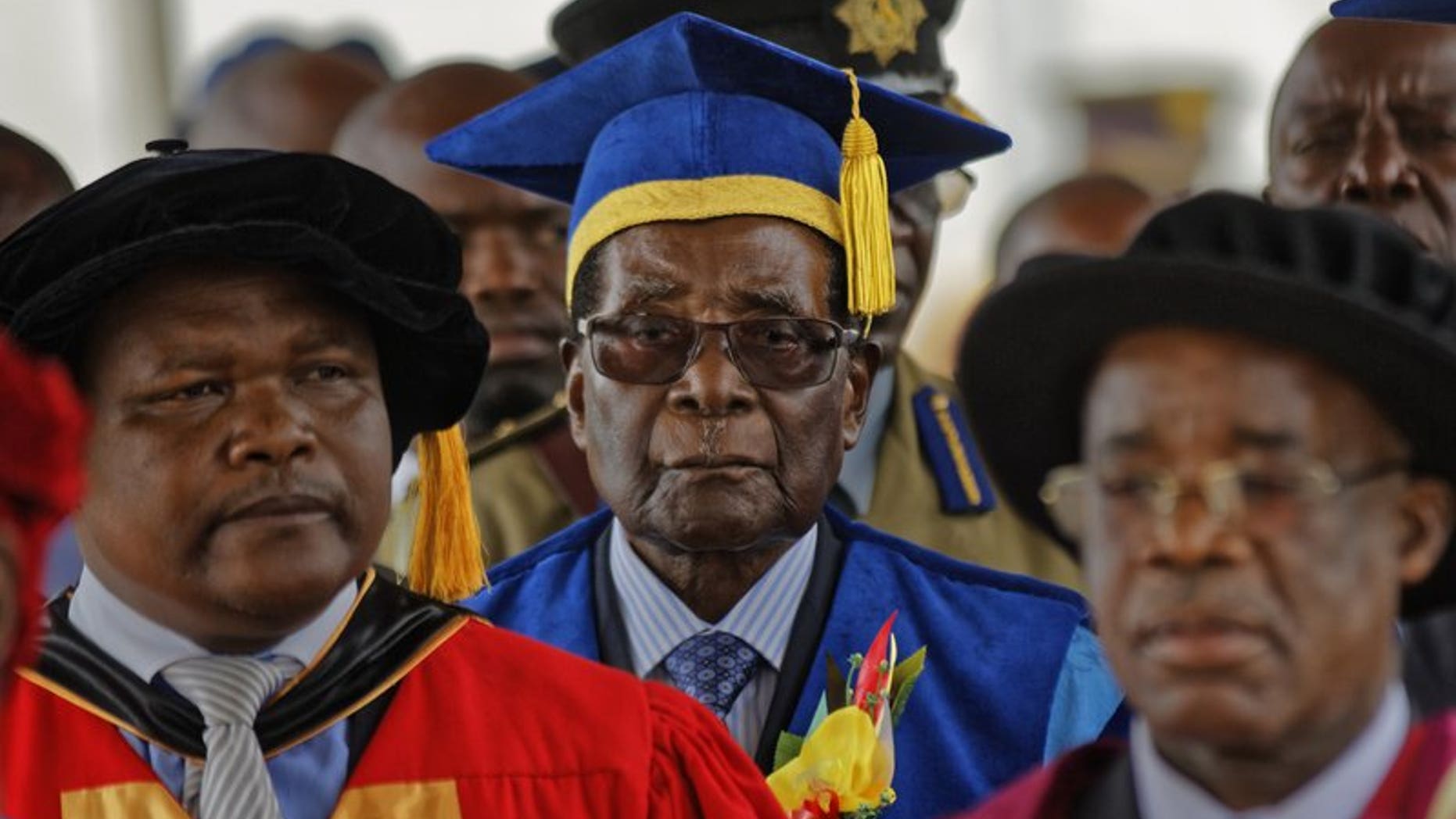 Zimbabwe's President Robert Mugabe, center, arrives to preside over a student graduation ceremony at Zimbambwe Open University, Nov. 17, 2017.