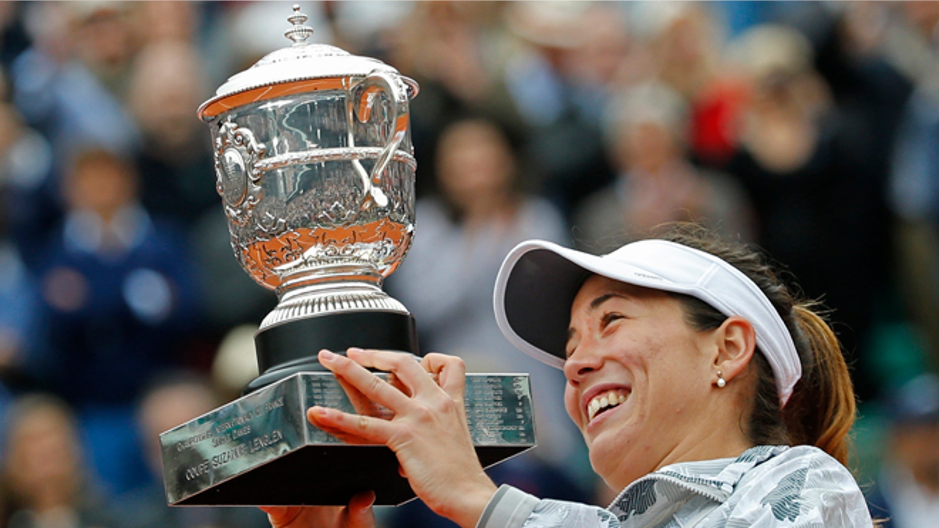 Spain's Garbine Muguruza holds the trophy after winning the final of the French Open tennis tournament against Serena Williams of the U.S. in two sets 7-5, 6-4, at the Roland Garros stadium in Paris, France, Saturday, June 4, 2016. (AP Photo/Alastair Grant)