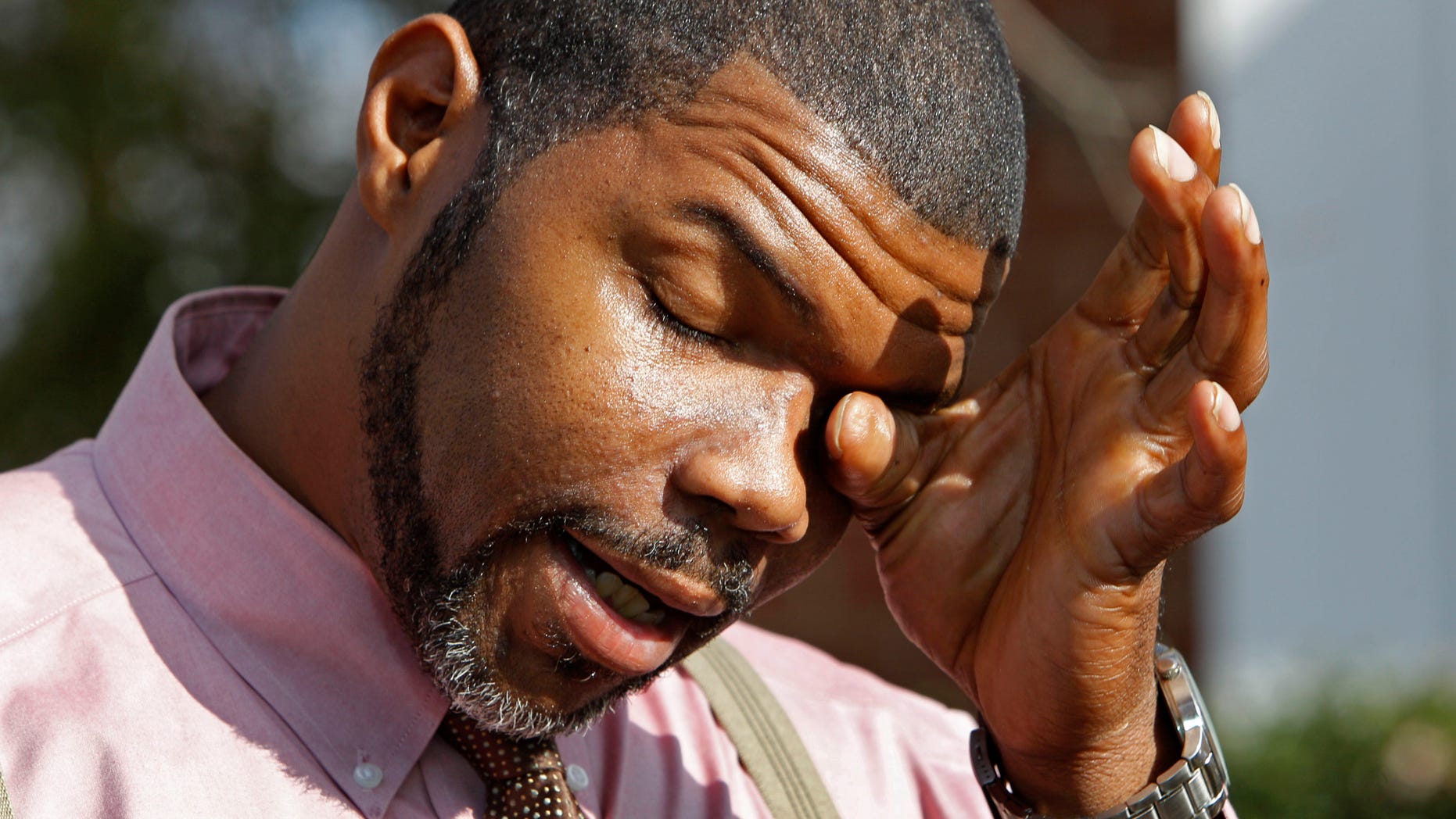 Nov. 23: Anthony Tisdale, right, father of Delvonte Tisdale, wipes his face during a news conference in front of his home in Charlotte, N.C.