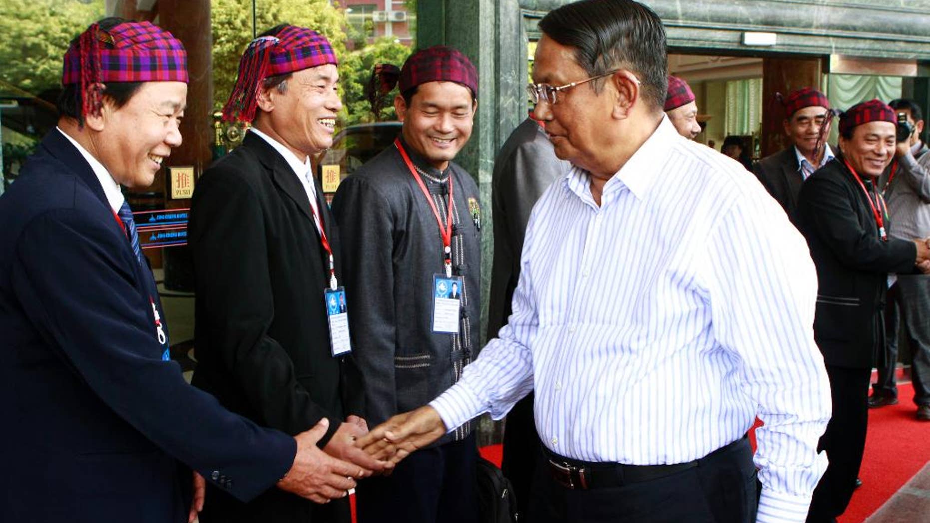 FILE - In this March 8, 2012 file photo, Aung Thaung, right, leader of Myanmar's government peace committee, shakes hands with a member of the Kachin Independence Organization during a signing ceremony of a peace agreement between the two sides, at Jin Cheng hotel in China's Shwe-Li town on the China-Myanmar border. The Myanmar Parliament has denounced a U.S. move to blacklist ruling party lawmaker Aung Thaung and says the decision could adversely affect bilateral relations. The announcement on Monday, Nov. 10, 2014, said the decision by the U.S. Treasury Department to blacklist Aung Thaung tarnishes the dignity of the lawmakers and parliamentary committees, one of which he leads. (AP Photo/Khin Maung Win, File)