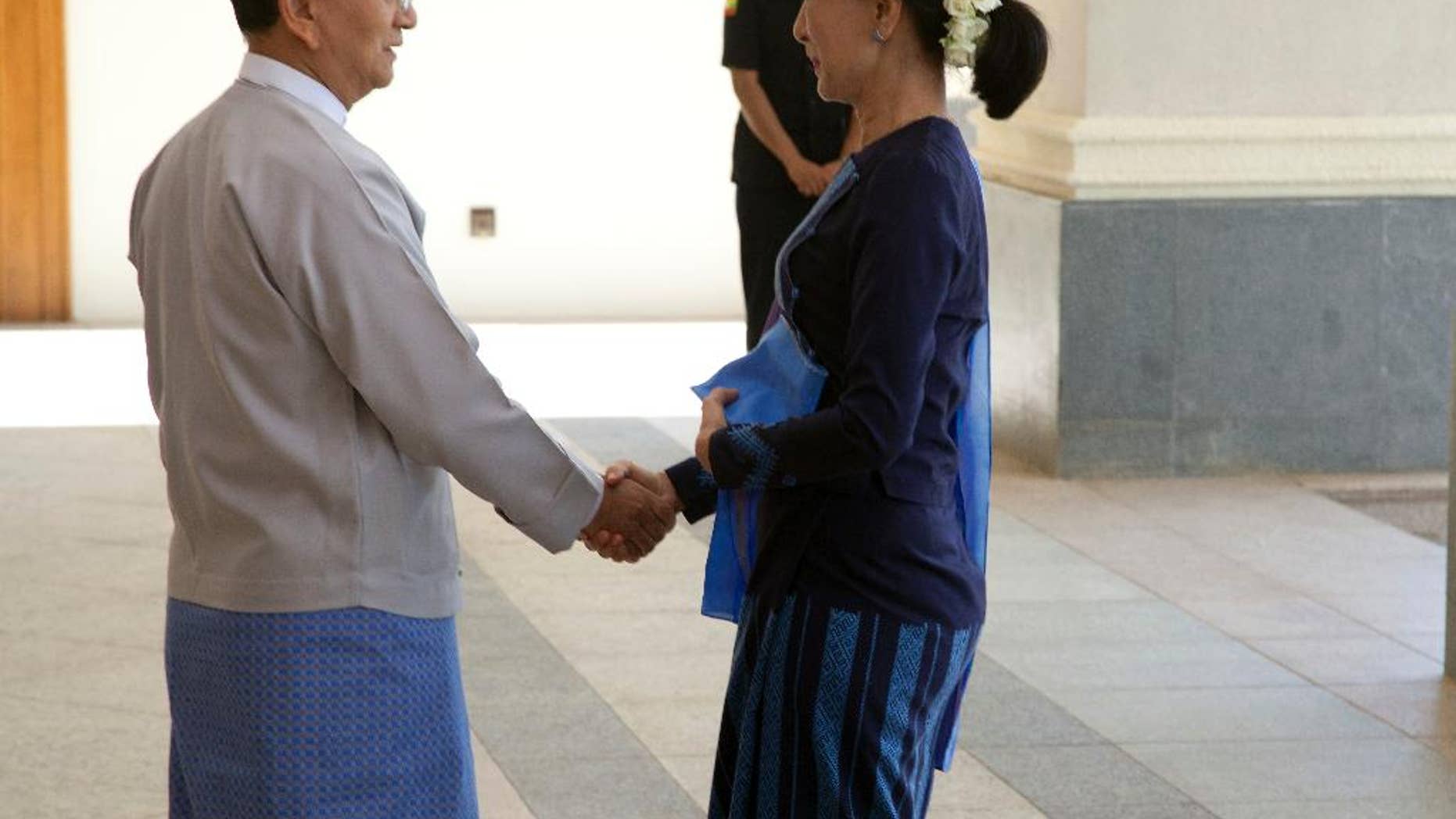 Myanmar President Thein Sein, left, shakes hands with Myanmar opposition leader Aung San Suu Kyi during their meeting at Myanmar Presidential Palace in Naypyitaw, Myanmar Friday, Oct 31, 2014. Myanmar's president is holding a rare meeting with Suu Kyi that also includes the country's political and military heavyweights. (AP Photo/Khin Maung Win)