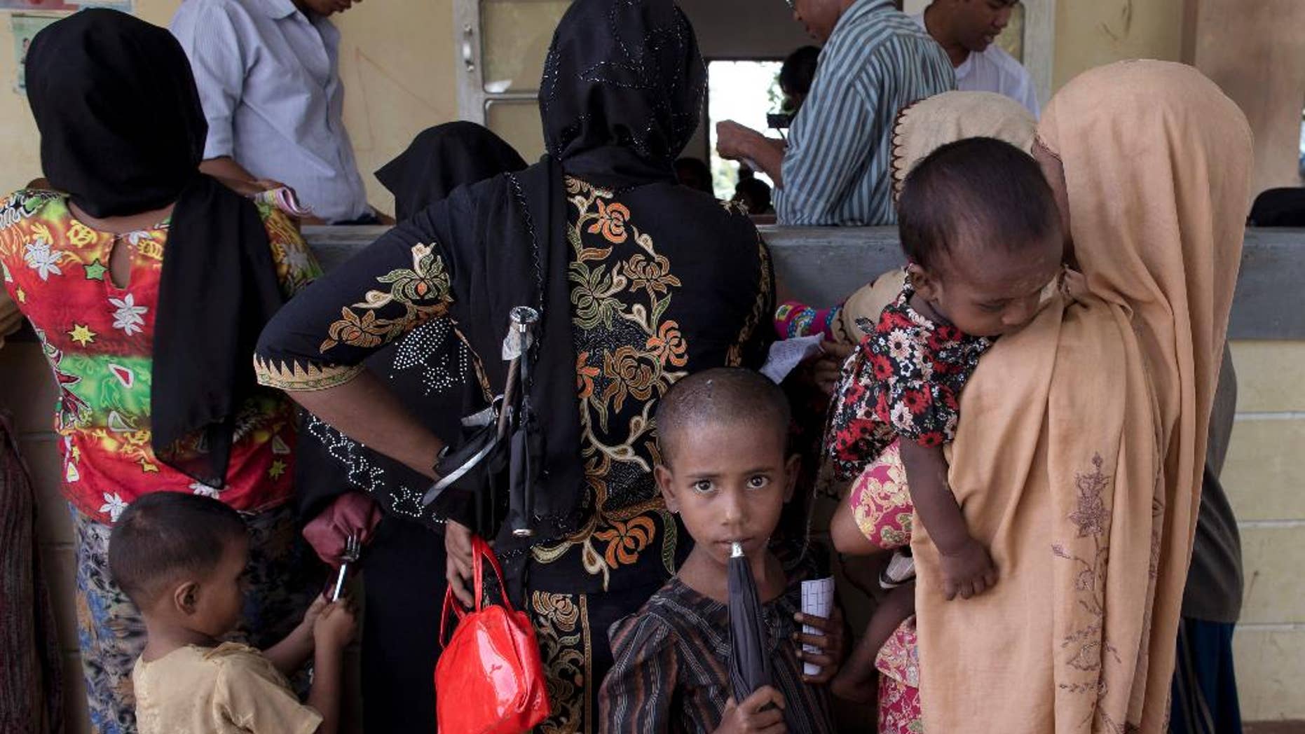 FILE - In this June 25 2014 file photo, Rohingya refugees gather to receive medicine at Dar Paing village clinic, north of Sittwe, Rakhine state, Myanmar. A growing sense of desperation is fueling a mass exodus of Rohingya Muslims from western Myanmar, with at least 8,000 members of the long-persecuted minority fleeing by boat in the last two weeks, according to residents and a leading expert. (AP Photo/Gemunu Amarasinghe, File)