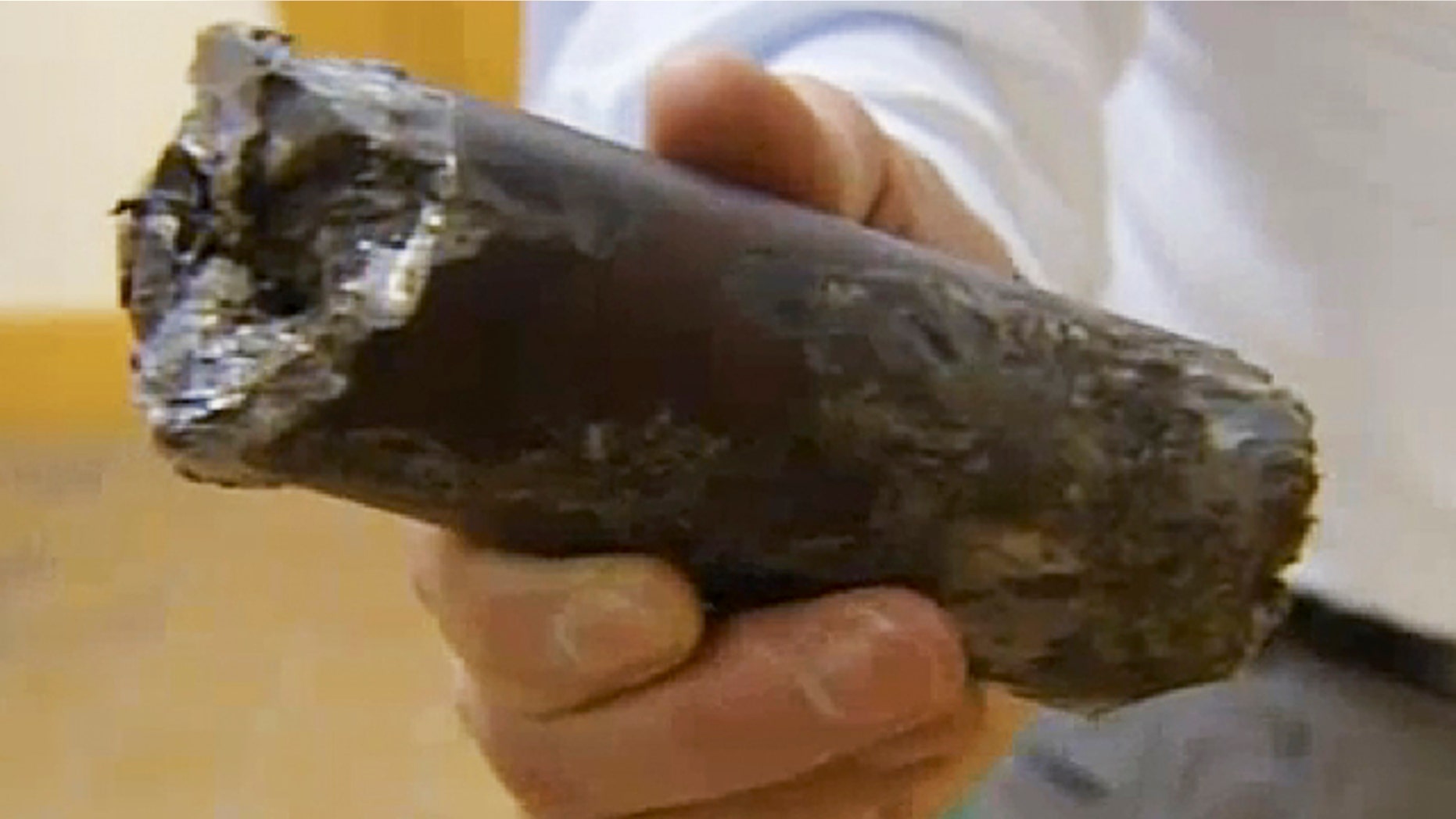 Dec. 1, 2011: A still image from video provided by New England Cable News shows a chunk of metal that plunged through the roof of Michael's Furniture Warehouse in Plymouth, Mass.