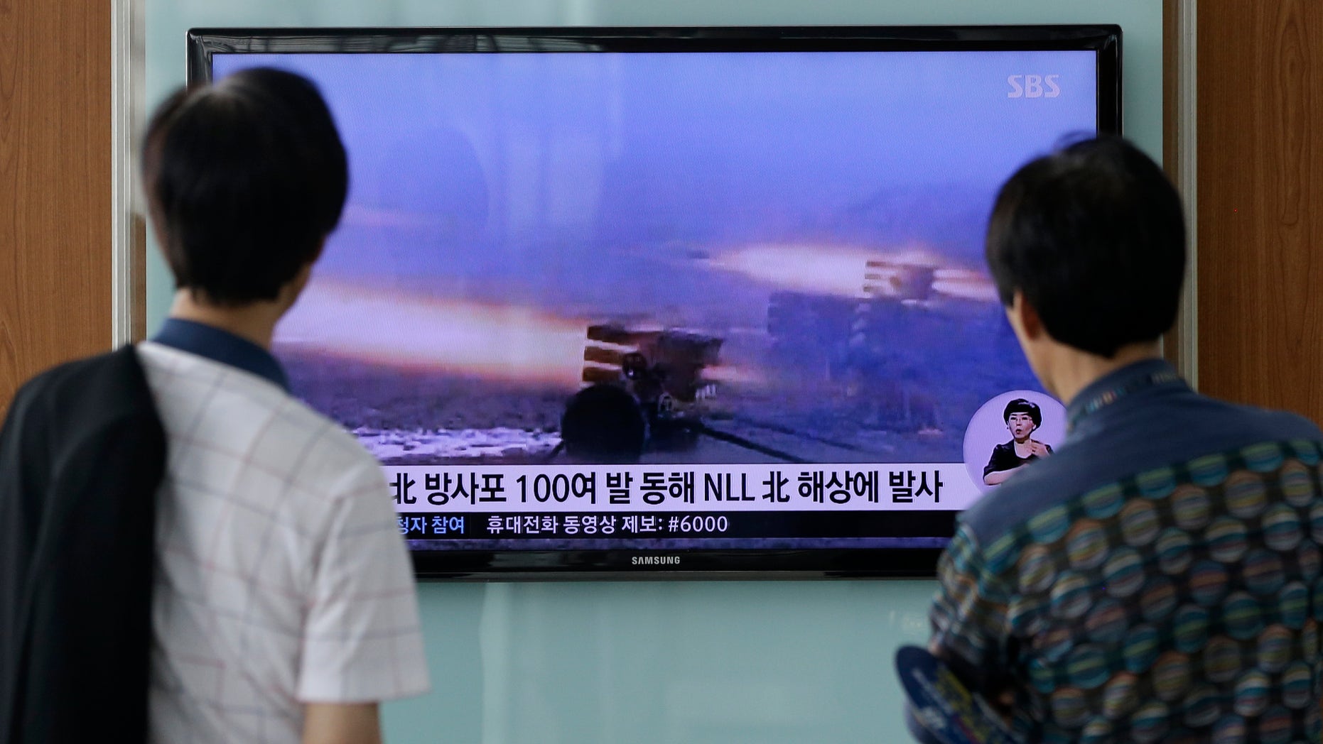 July 14, 2014 - People at Seoul Railway Station in Seoul, South Korea, watch a TV news report on North Korea firing artillery shells into waters near its sea border with South Korea, Seoul's military said, a day after the country test-launched two ballistic missiles in the latest of a series of weapon tests.