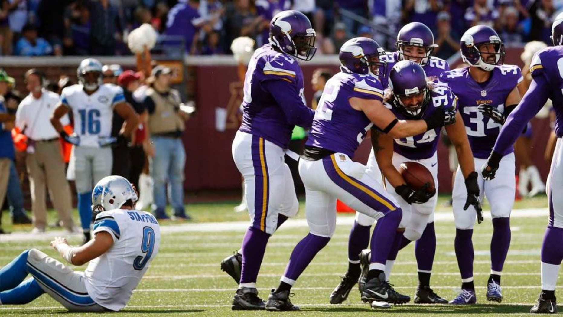 Sunday, Sept. 20: Minnesota Vikings defensive end Justin Trattou celebrates his interception as Detroit Lions quarterback Matthew Stafford sits on the field in the second half in Minneapolis. The Vikings won 26-16.