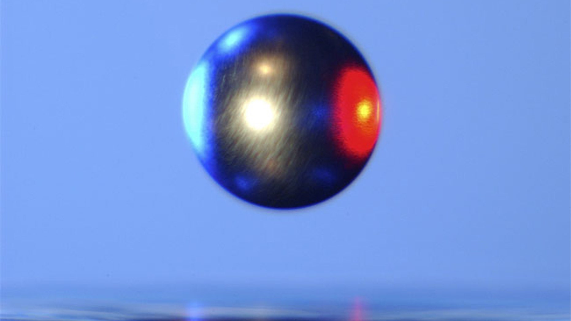 Inside a NASA Electrostatic Levitator, a ball of metal is suspended in mid-air by static electricity.