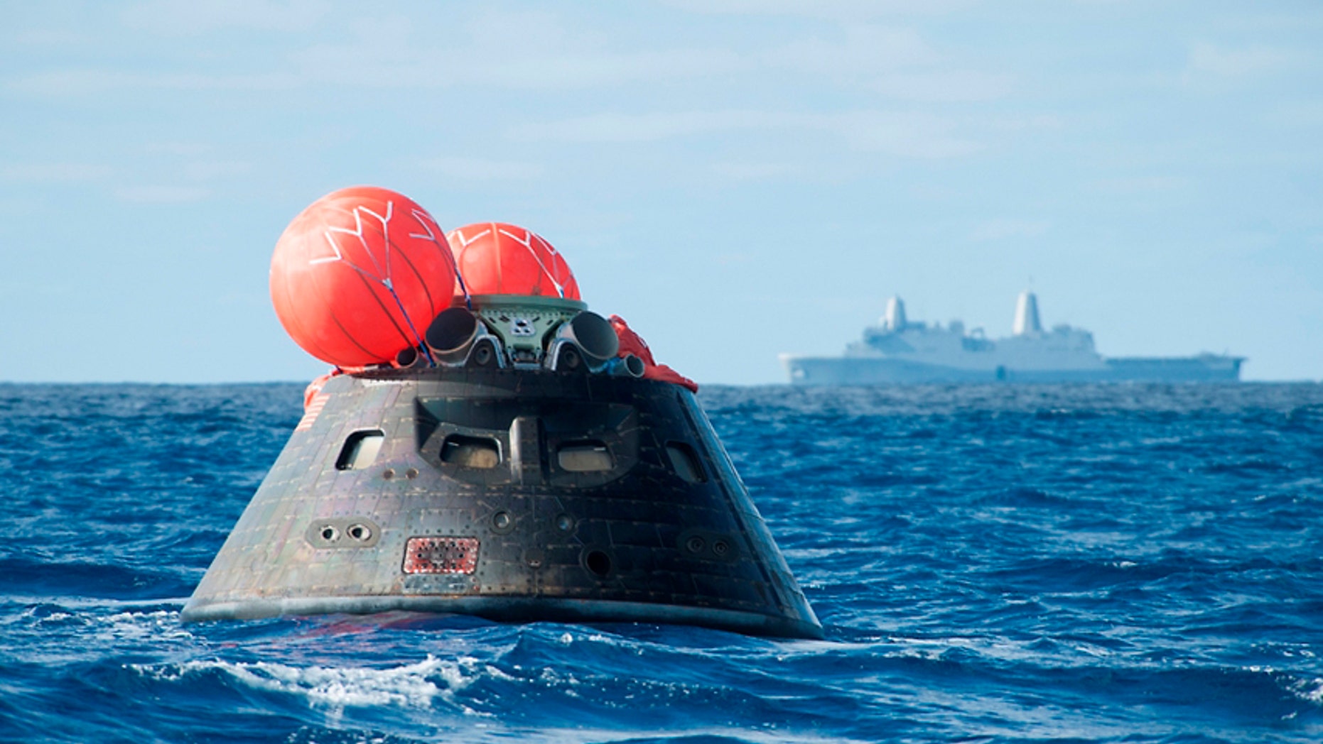 This Dec. 5, 2014 image provided by NASA shows NASA's Orion spacecraft after splash down as it awaits the U.S. Navy's USS Anchorage in the Pacific ocean.