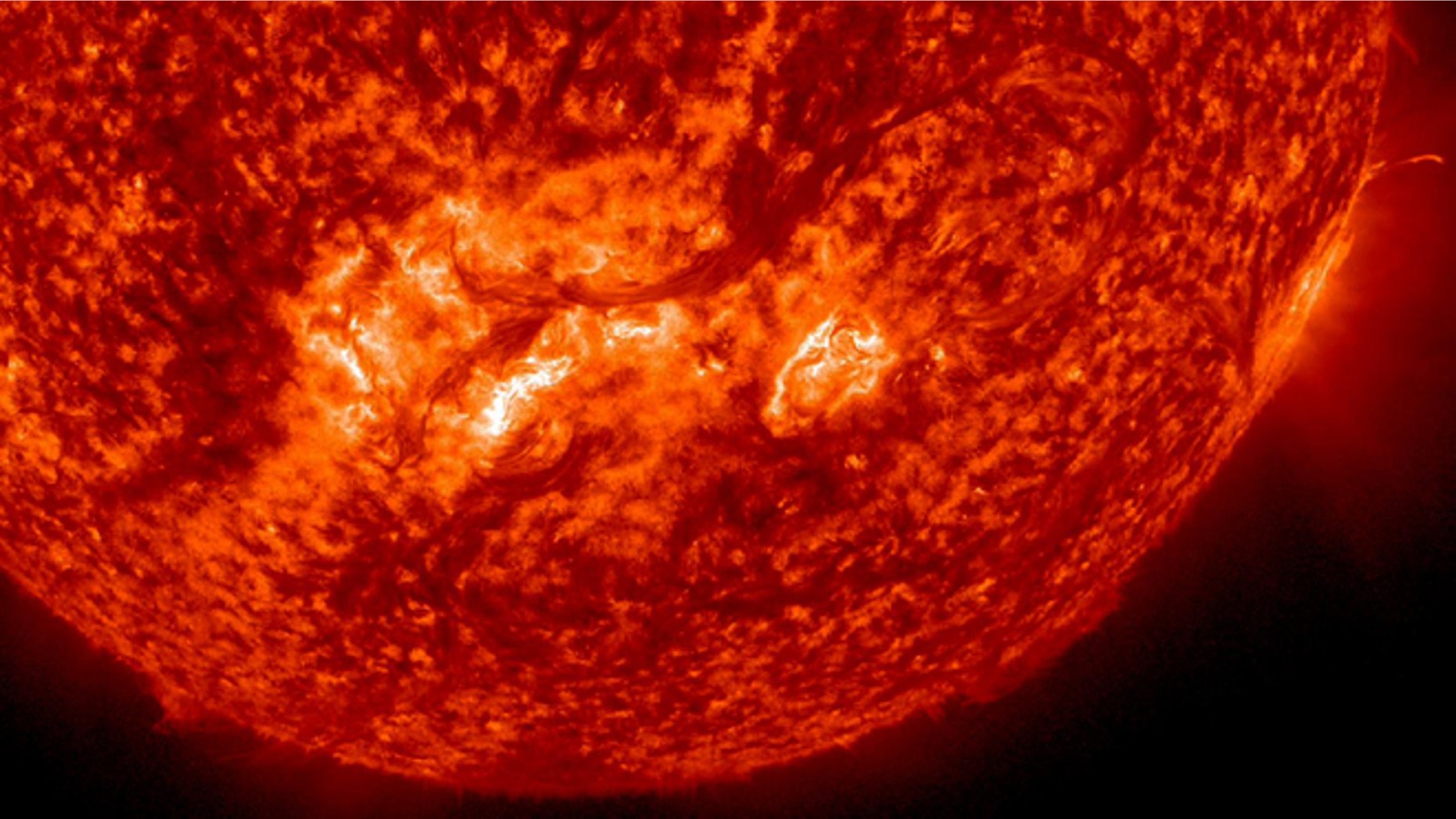A very long, whip-like solar filament extends over half a million miles in a long arc above the suns surface.