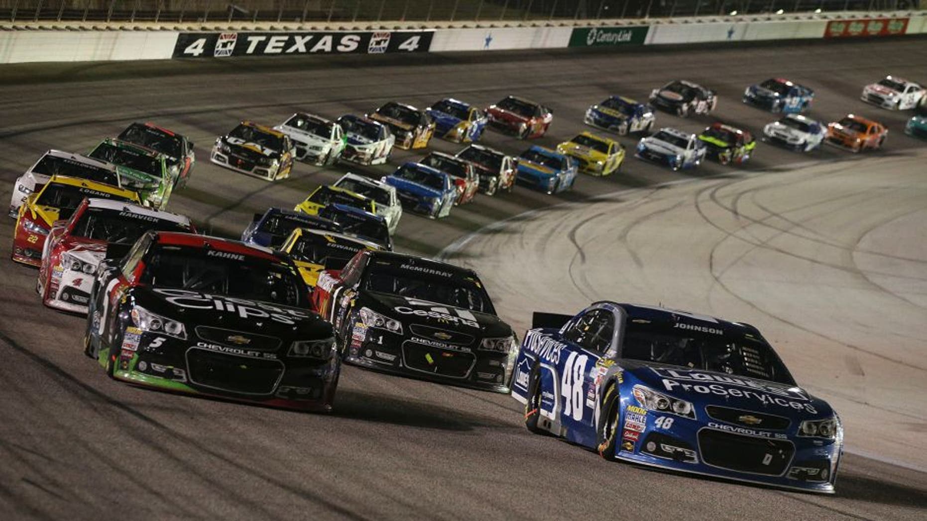 Jimmie Johnson, driver of the #48 Lowe's Pro Services Chevrolet, races with Kasey Kahne, driver of the #5 Great Clips Chevrolet, during the NASCAR Sprint Cup Series Duck Commander 500 at Texas Motor Speedway on April 11, 2015 in Fort Worth, Texas.