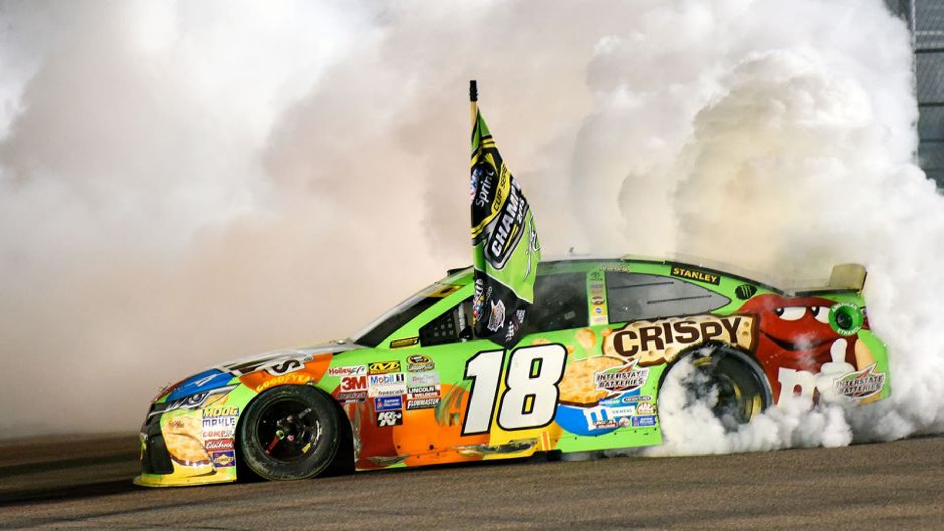 HOMESTEAD, FL - NOVEMBER 22: Kyle Busch, driver of the #18 M&M's Crispy Toyota, celebrates winning the series championship and the race with a burnout after the NASCAR Sprint Cup Series Ford EcoBoost 400 at Homestead-Miami Speedway on November 22, 2015 in Homestead, Florida. (Photo by Jared C. Tilton/NASCAR via Getty Images)