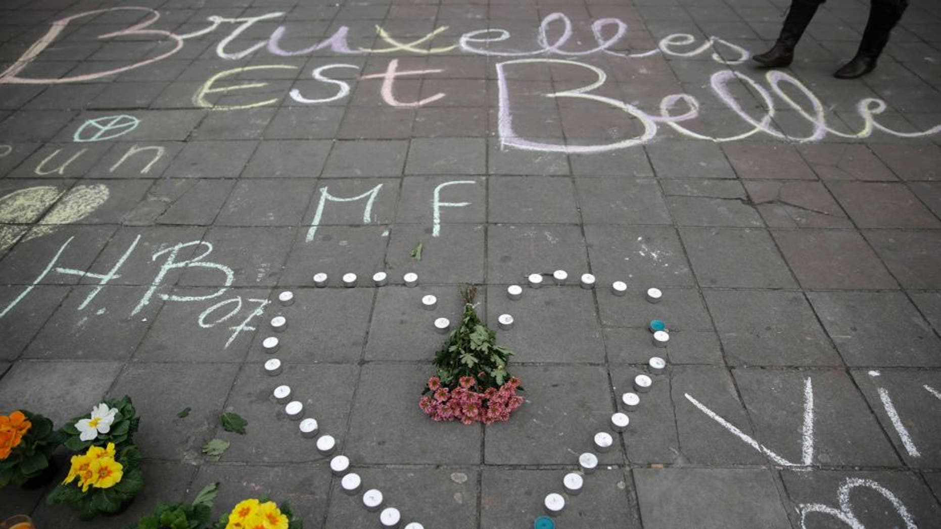 A message written on the ground reads "Brussels is beautiful" next to flowers and candles following attacks in Brussels on March 22, 2016. Airlines cancelled hundreds of flights and European railways froze links with Brussels after a series of bomb blasts killed around 35 people in the city's airport and a metro train, sparking a broad security response. AFP PHOTO / KENZO TRIBOUILLARD / AFP / KENZO TRIBOUILLARD (Photo credit should read KENZO TRIBOUILLARD/AFP/Getty Images)