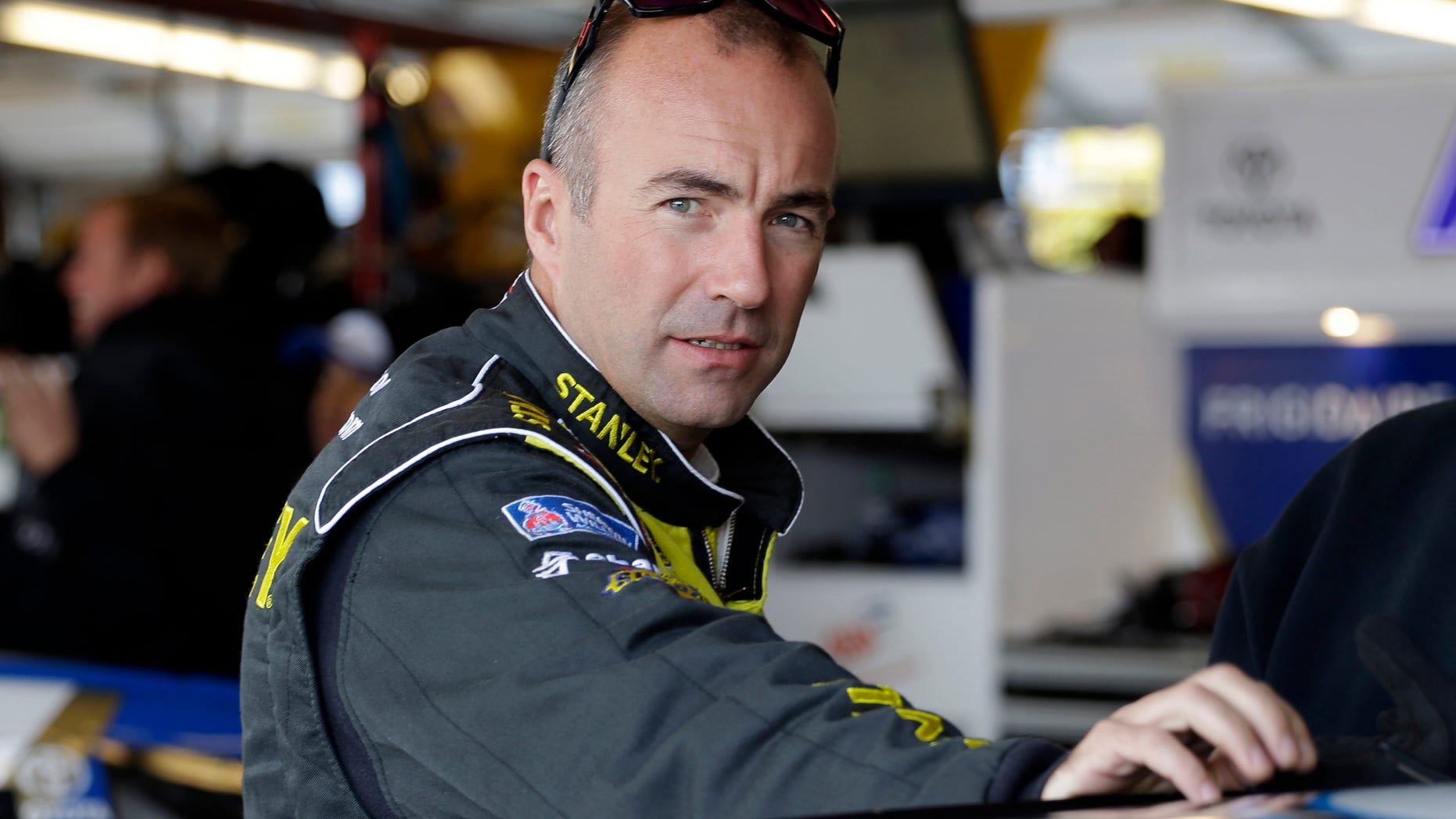 Driver Marcos Ambrose, of Australia, looks toward the outside from his garage during final practice for the NASCAR Sprint Cup Series auto race at Chicagoland Speedway in Joliet, Ill., Saturday, Sept. 13, 2014. Ambrose will leave NASCAR at the end of the season and return to his native Australia (AP Photo/Nam Y. Huh)