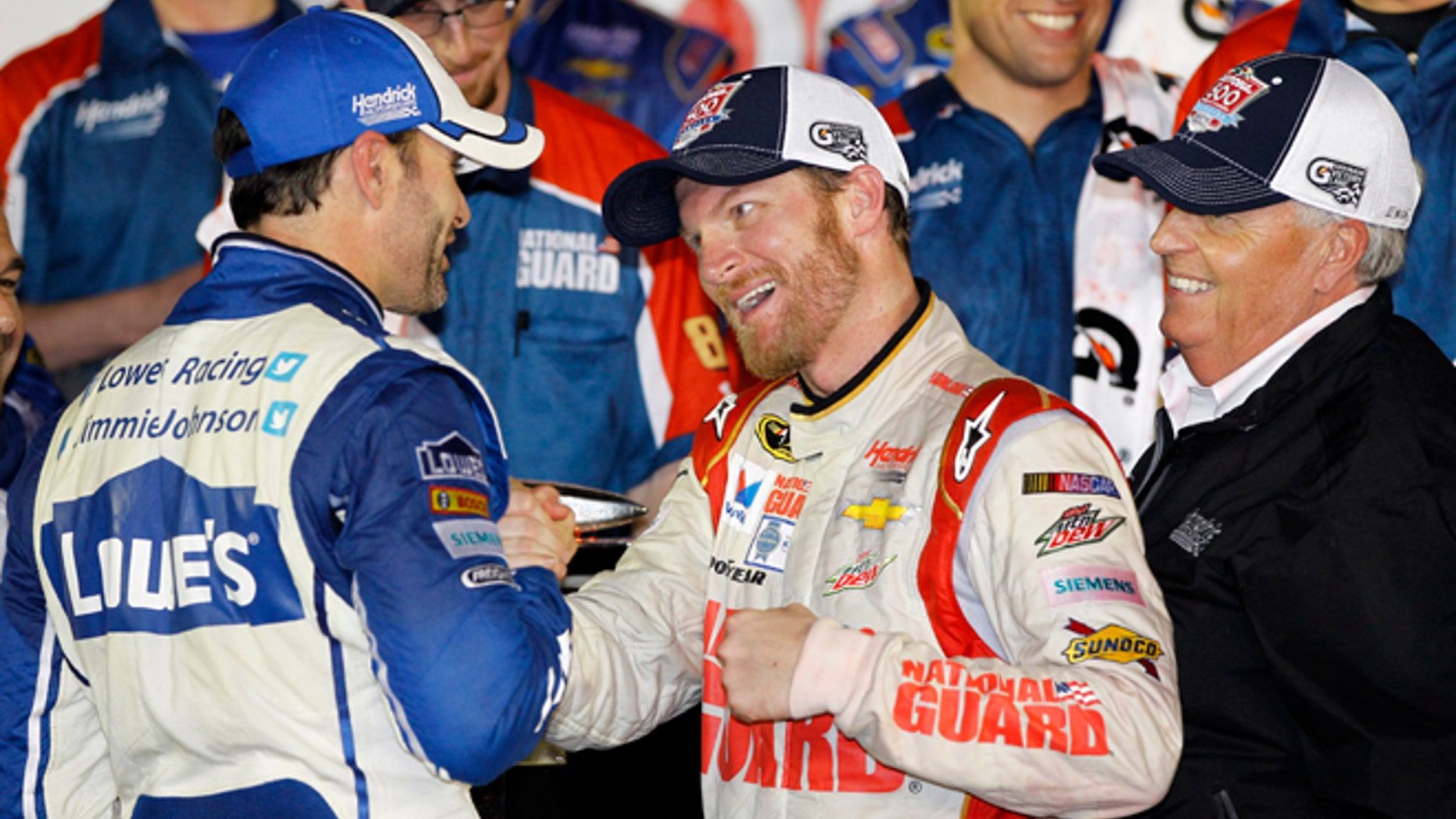 Dale Earnhardt Jr., center, celebrates in Victory Lane with teammate Jimmie Johnson, left, and team owner Rick Hendrick, right, after winning the NASCAR Daytona 500 Sprint Cup series auto race at Daytona International Speedway in Daytona Beach, Fla., Sunday, Feb. 23, 2014. (AP Photo/Terry Renna)