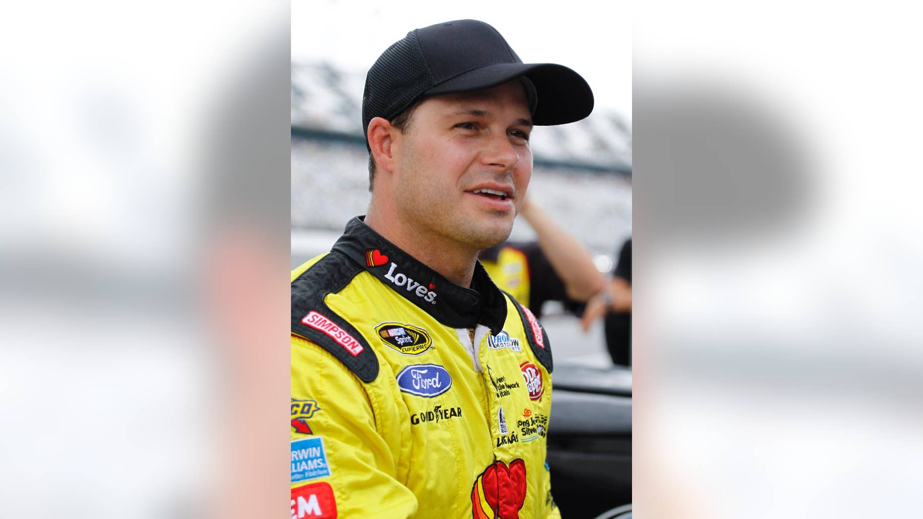 David Gilliland talks with reporters after qualifying for the pole position in the NASCAR Sprint Cup Series auto race after the event was shortened due to rain at Daytona International Speedway in Daytona Beach, Fla., Friday, July 4, 2014. (AP Photo/Terry Renna)