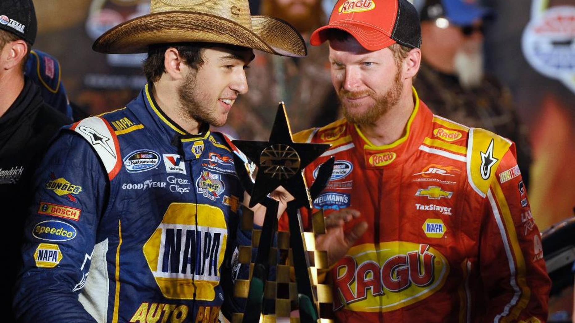FILE - In this April 4, 2014, photo, Chase Elliott, left, talks with team owner Dale Earnhardt Jr. in Victory Lane after Elliott won the NASCAR Nationwide auto race at Texas Motor Speedway in Fort Worth, Texas. Elliott's driving skills have made it easy to forget he's still in high school. That changes this weekend when the NASCAR Nationwide points leader sandwiches graduation around a trip to Iowa Speedway for a key early-season race. (AP Photo/Ralph Lauer, File)