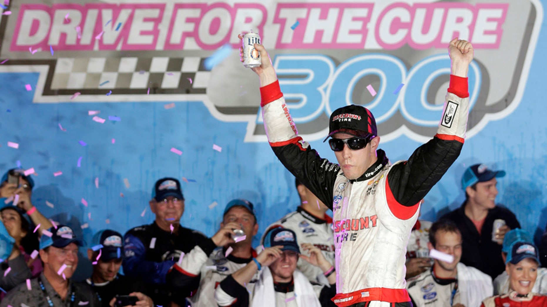 Brad Keselowski celebrates in Victory Lane after winning the NASCAR Nationwide series Drive for the Cure 300 auto race at Charlotte Motor Speedway in Concord, N.C., Friday, Oct. 10, 2014. (AP Photo/Chuck Burton)