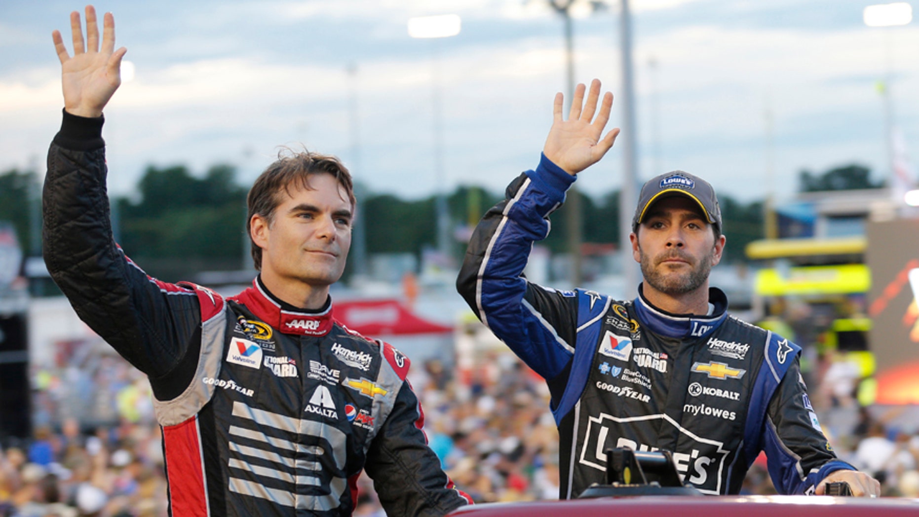 Jeff Gordon, left, and Jimmie Johnson wave to the crowd during driver introductions for the NASCAR Sprint Cup series auto race at Richmond International Raceway in Richmond, Va., Saturday, Sept. 6, 2014. (AP Photo/Steve Helber)