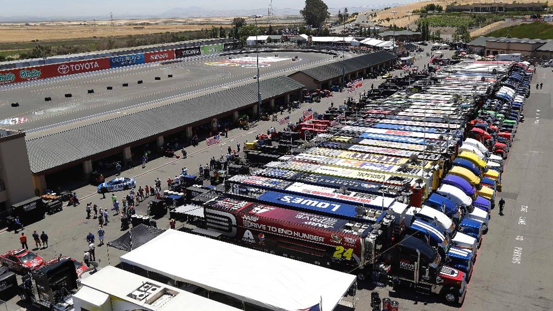 Jeff Gordon, left, pulls his car into the garage during practice for the NASCAR Sprint Cup Series auto race Friday, June 20, 2014, in Sonoma, Calif. (AP Photo/Eric Risberg)