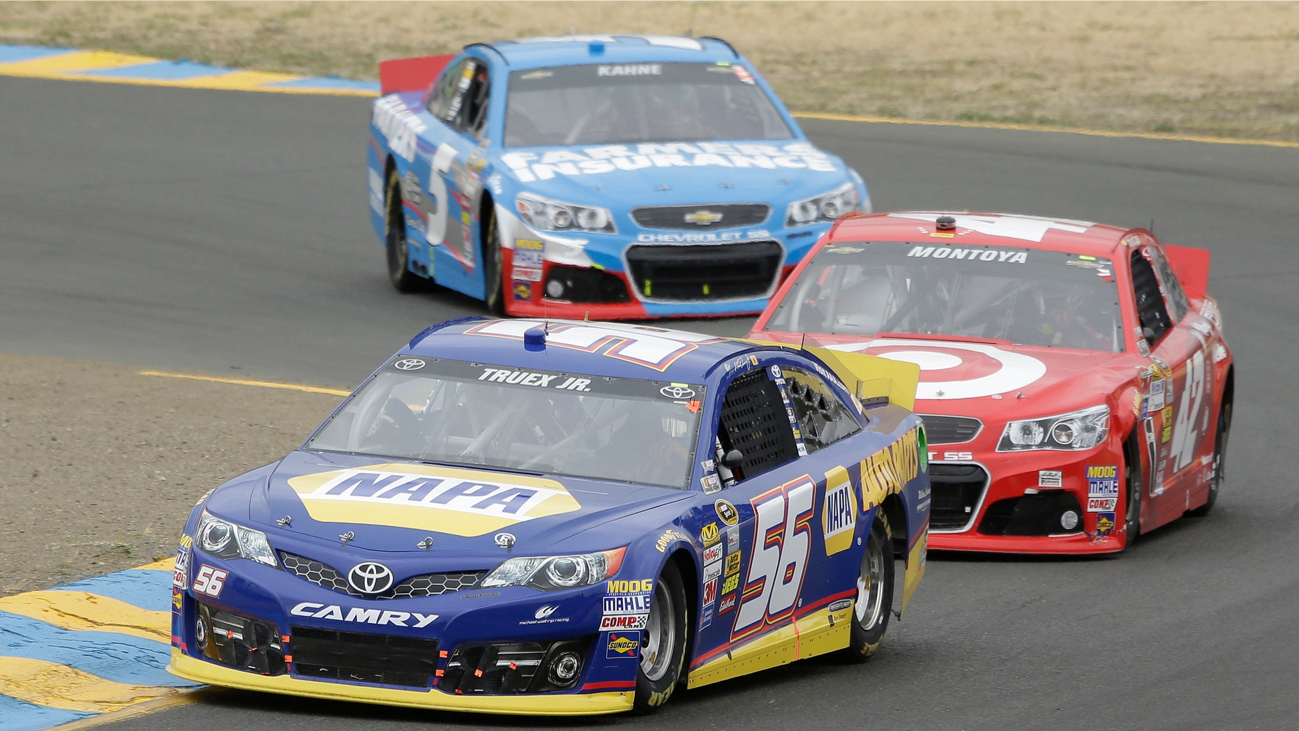 Martin Truex Jr. (56) leads Juan Pablo Montoyo, of Colombia, and Kasey Kahne through Turn 2 in a NASCAR Sprint Cup Series auto race on Sunday, June 23, 2013, in Sonoma, Calif. Truex Jr. won the race. (AP Photo/Eric Risberg)