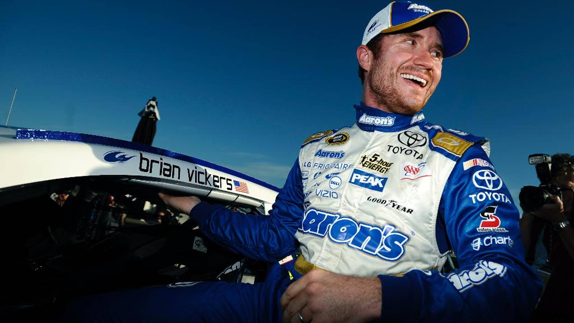 Brian Vickers climbs out of his car after winning the pole for Sunday's NASCAR Sprint Cup Series auto race at Talladega Superspeedway Saturday, Oct. 18, 2014, in Talladega, Ala. (AP Photo/Rainier Ehrhardt)