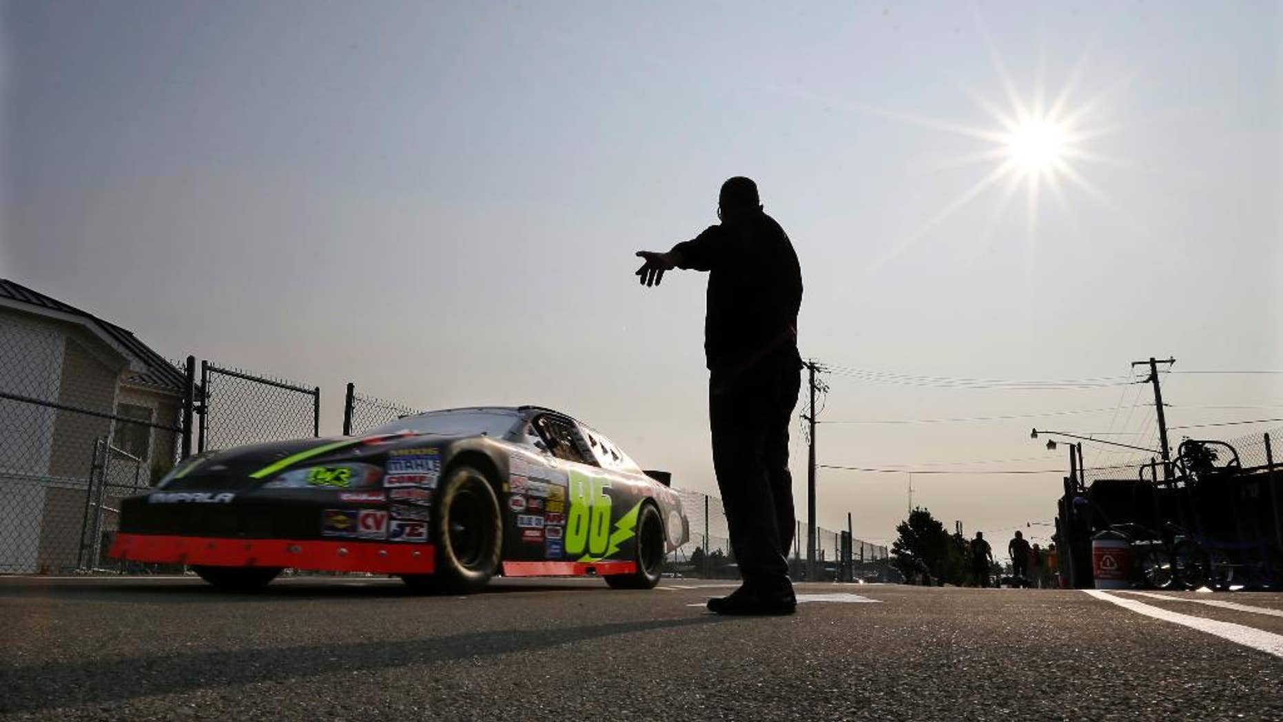 A race car heads out to the track during an early morning practice session for a NASCAR K&N Pro Series auto race at Watkins Glen International, Friday, Aug. 8, 2014, in Watkins Glen N.Y. (AP Photo/Mel Evans)