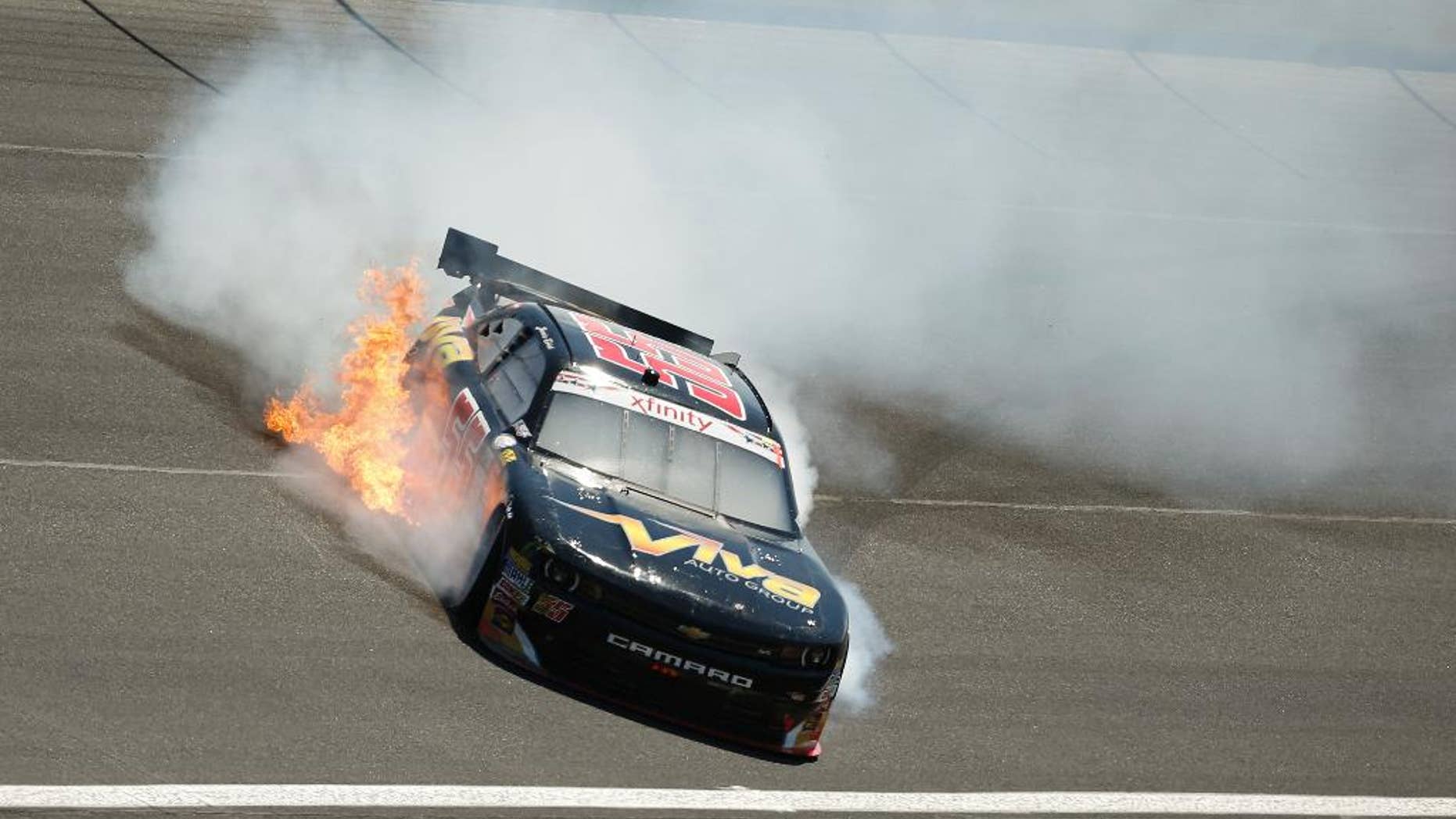 Flames shoot from Jamie Dick's car after he hit the wall during the NASCAR Xfinity series auto race at Charlotte Motor Speedway in Concord, N.C., on Saturday, May 23, 2015. (AP Photo/Chris Keane)