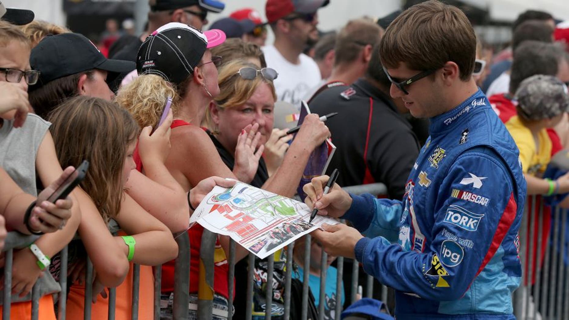 INDIANAPOLIS, IN - JULY 26: Landon Cassill, driver of the #40 Chevrolet, signs autographs for fans prior to the NASCAR Sprint Cup Series Crown Royal Presents the Jeff Kyle 400 at the Brickyard at Indianapolis Motor Speedway on July 26, 2015 in Indianapolis, Indiana. (Photo by Sean Gardner/NASCAR via Getty Images)