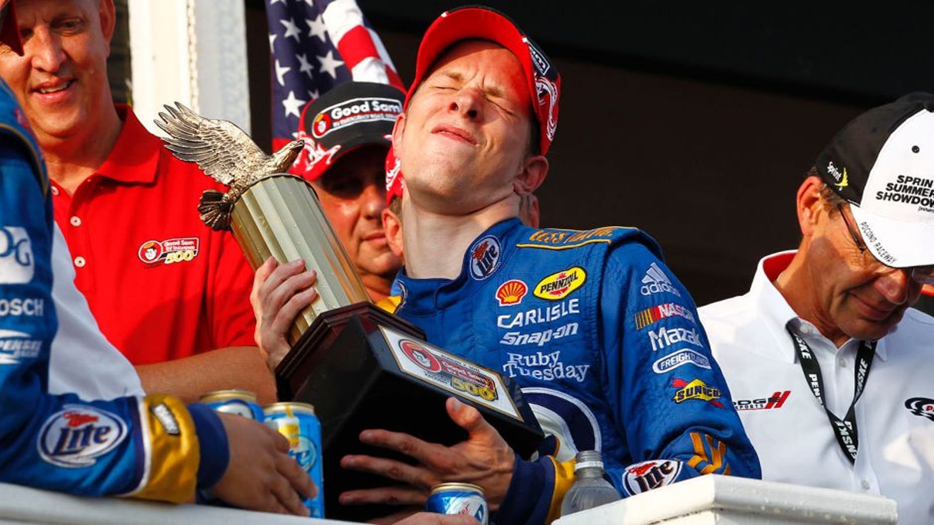 5-7 August, 2011, Long Pond, Pennsylvania USA Brad Keselowski winces in pain lifting the trophy (c)2011, Dan Streck LAT Photo USA