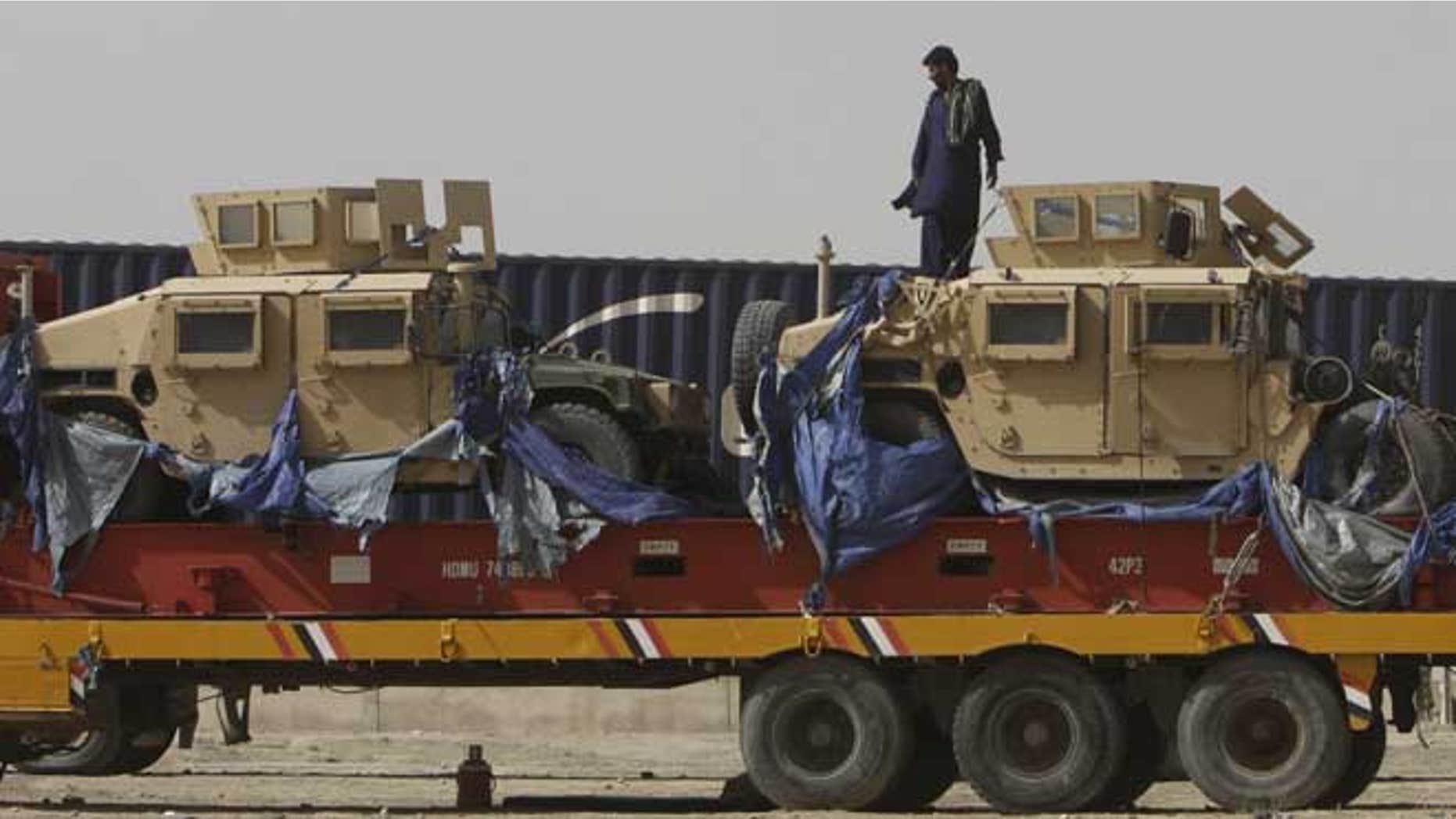July 4, 2012: A driver stands on top of a truck carrying NATO Humvees at a terminal in the Pakistani-Afghan border, in Chaman, Pakistan.