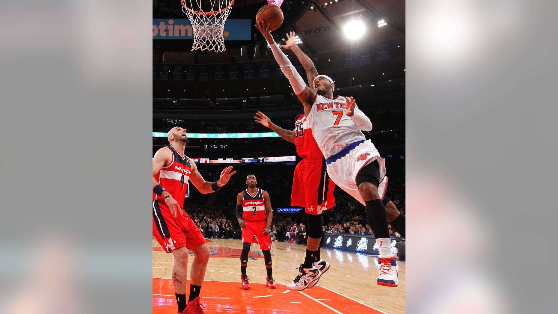 FILe - In this Dec. 16, 2013 file photo, New York Knicks' Carmelo Anthony (7) goes to the basket against Washington Wizards' Trevor Booker (35) during the first half of an NBA basketball game in New York. Signing day has arrived in the NBA, if the biggest free agents care to grab their pens. But it’s unclear if Carmelo Anthony, Chris Bosh and Dwyane Wade _ who all might be waiting on LeBron James to go first _ are ready.(AP Photo/Jason DeCrow, File)