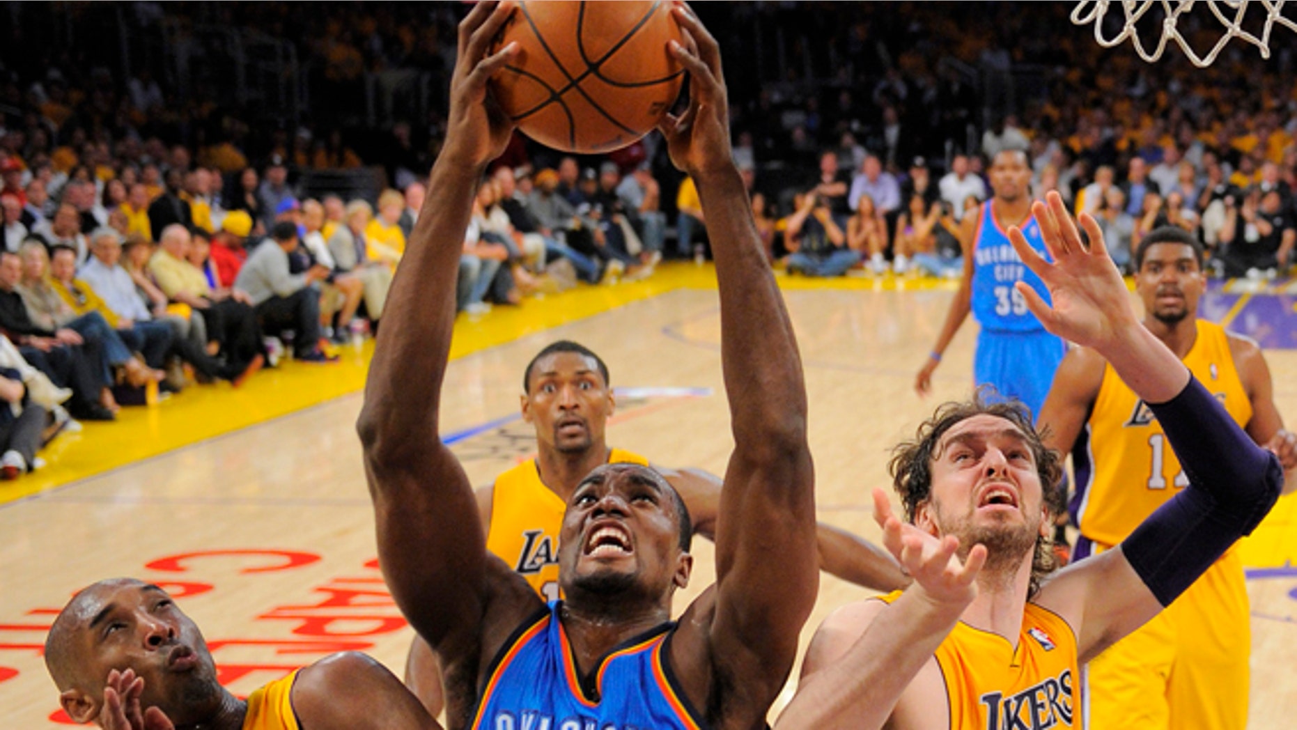 Oklahoma City Thunder forward Serge Ibaka of Congo, center, grabs a rebound as Los Angeles Lakers guard Kobe Bryant, left, and forward Pau Gasol of Spain look on during the first half in Game 3 of an NBA basketball playoffs Western Conference semifinal, Friday, May 18, 2012, in Los Angeles. (AP Photo/Mark J. Terrill)