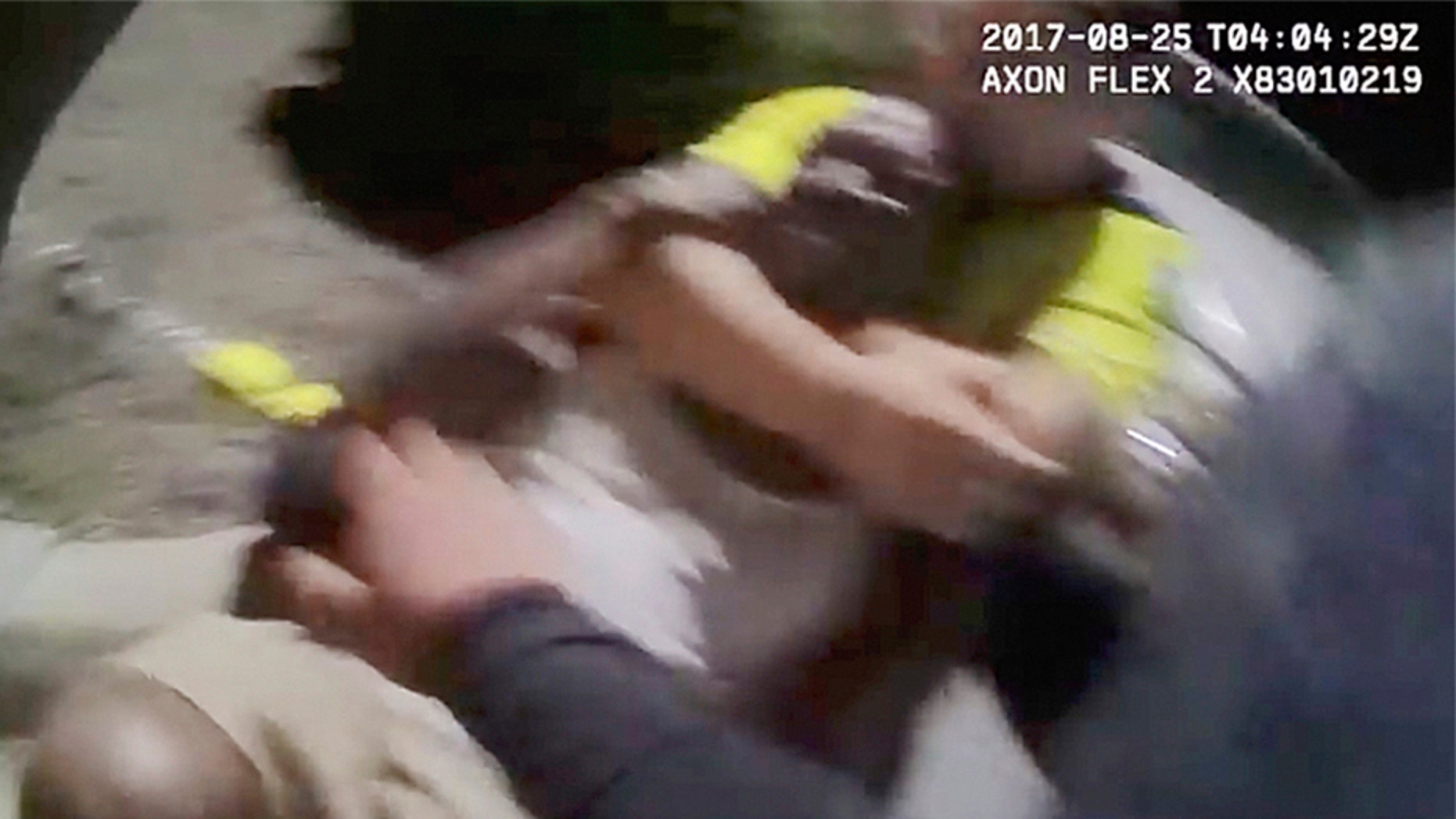 In this Aug. 25, 2017 image made from video and released by the Asheville, (N.C.) Police Department, Johnnie Jermaine Rush grimaces after officer Christopher Hickman overpowers Rush in a chokehold, in Asheville, N.C.