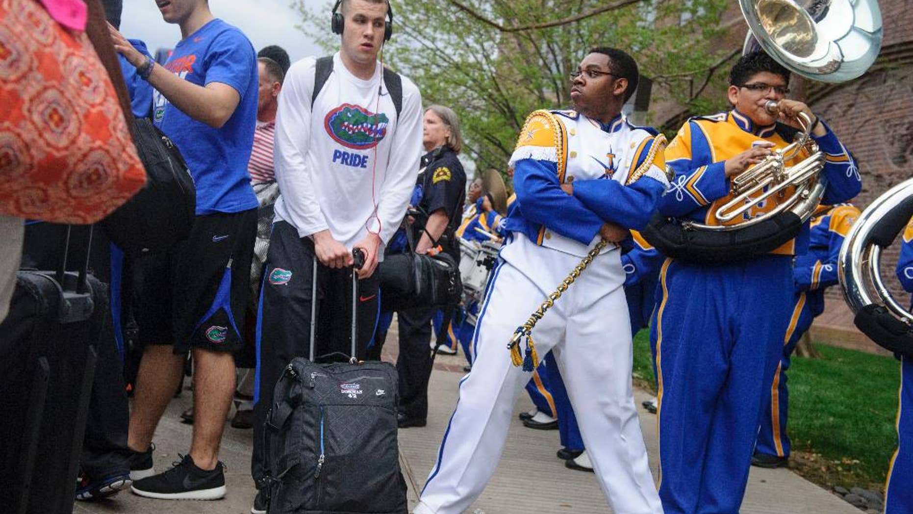Florida's Billy Donovan, center left, walks past drum major Khyree Henderson, second from right, and the Townview Marching Band outside a hotel in Dallas on Wednesday, April 2, 2014. Florida plays Connecticut on Saturday in the semifinals of the NCAA men's college basketball tournament in Arlington, Texas. (AP Photo/The Dallas Morning News, Matthew Busch) MANDATORY CREDIT; MAGS OUT; TV OUT; INTERNET USE BY AP MEMBERS ONLY; NO SALES