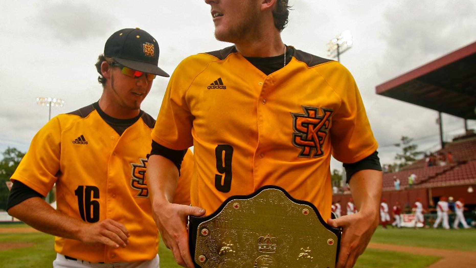 Kennesaw State's Will Lowman (16) helps winning pitcher Travis Bergen (9) adjust his championship belt after an NCAA college baseball tournament regional game against Alabama on Friday, May 30, 2014 in Tallahassee, Fla. Kennesaw State awards the belt to the player of the game when they win. Kennesaw State won 1-0. (AP Photo/Phil Sears)