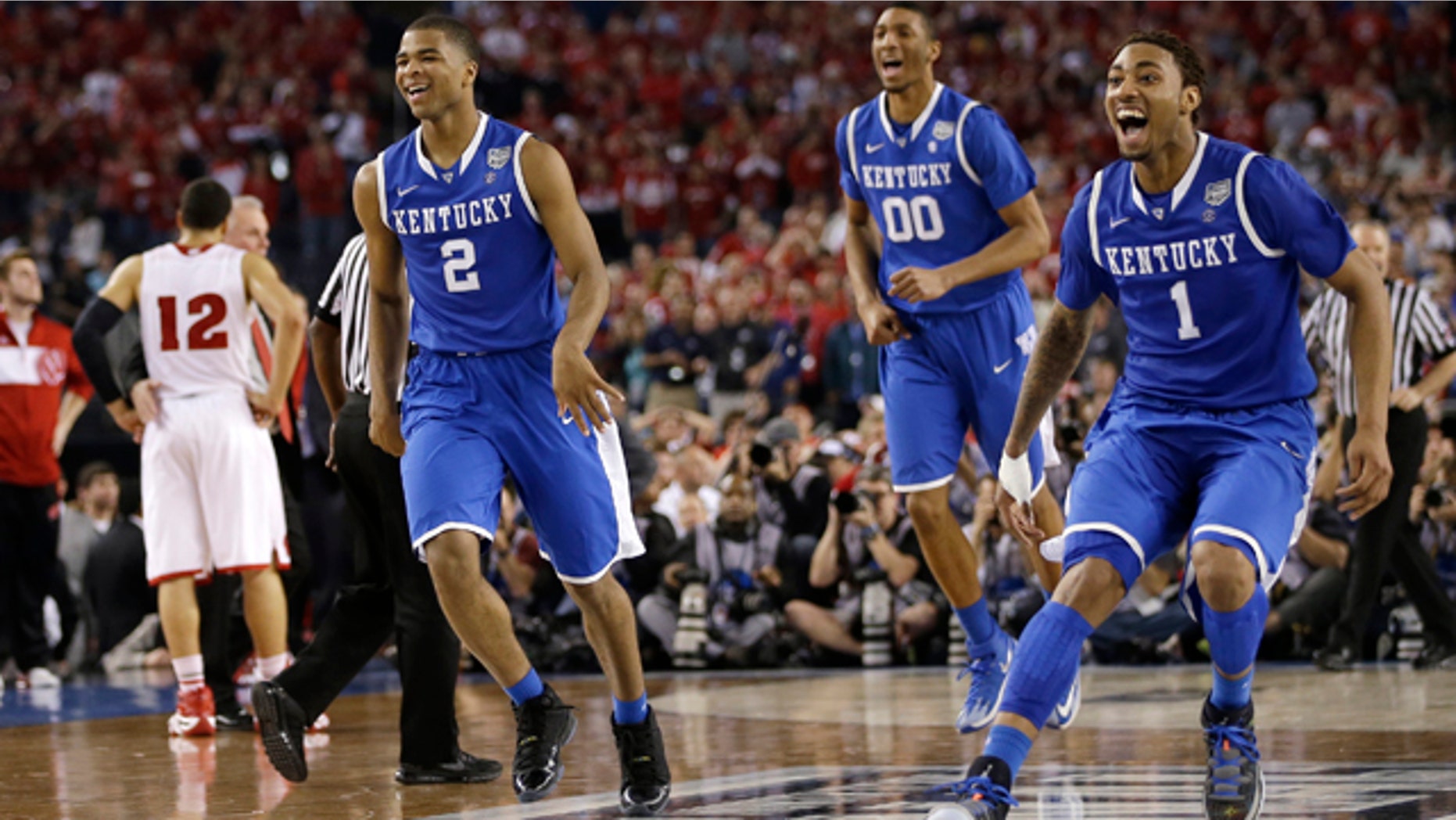 April 5, 2014: Kentucky's Aaron Harrison (2), Marcus Lee (00) and James Young, right, celebrate at the end of their 74-73 victory over Wisconsin in an NCAA Final Four tournament college basketball semifinal game in Arlington, Texas. (AP Photo/David J. Phillip)