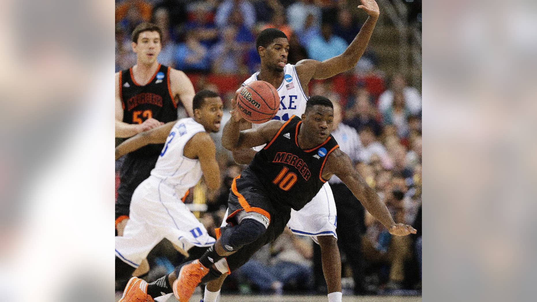 Mercer guard Ike Nwamu (10) moves the ball against Duke forward Amile Jefferson (21) during the second half of an NCAA college basketball second-round game, Friday, March 21, 2014, in Raleigh, N.C. (AP Photo/Chuck Burton)